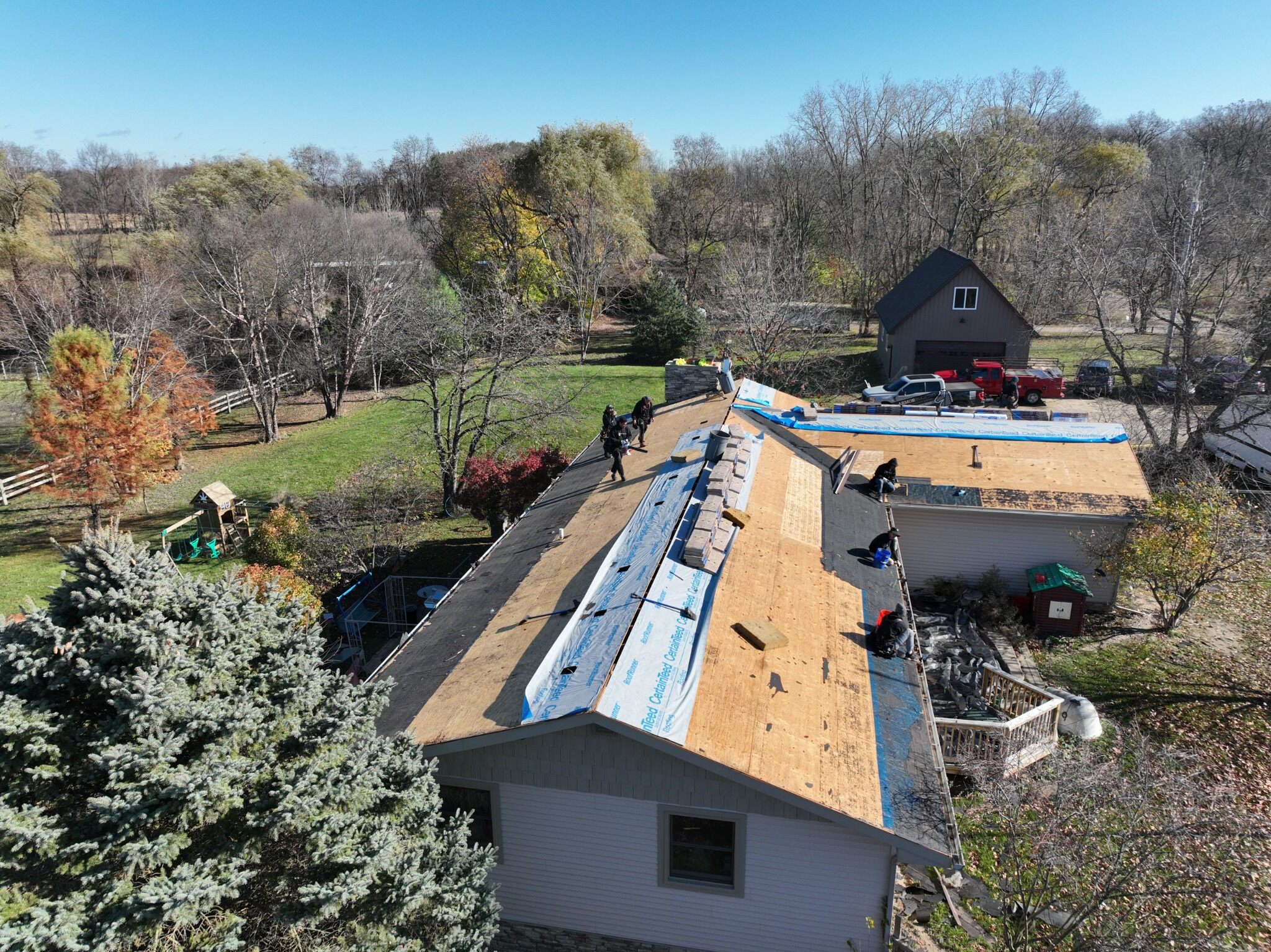 Aerial view of exposed roof decking and underlayment installation in progress