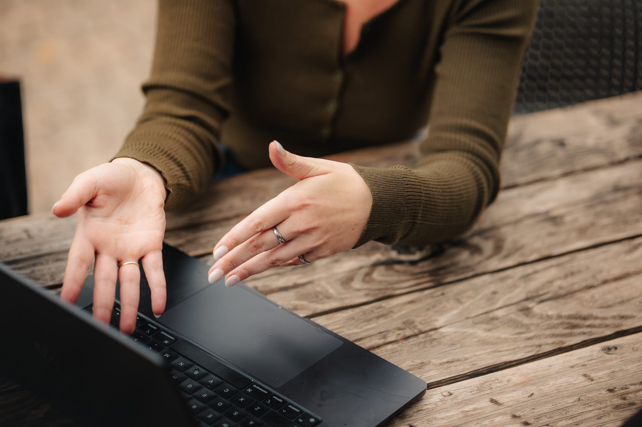 Ellen Bestland's hands on a laptop at a wooden table, working through a client's marketing plan