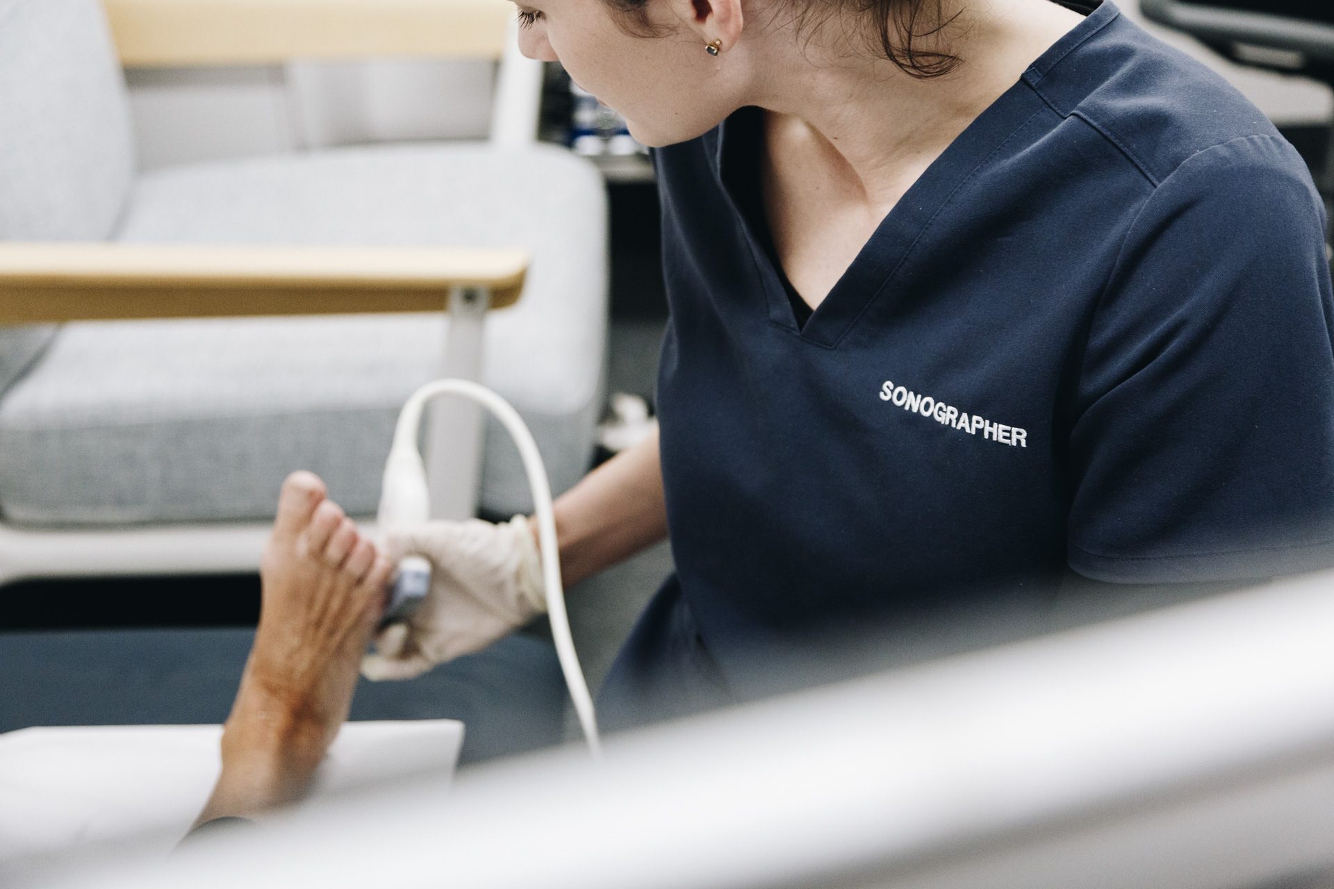 Sonographer performing a musculoskeletal ultrasound of a patient's foot