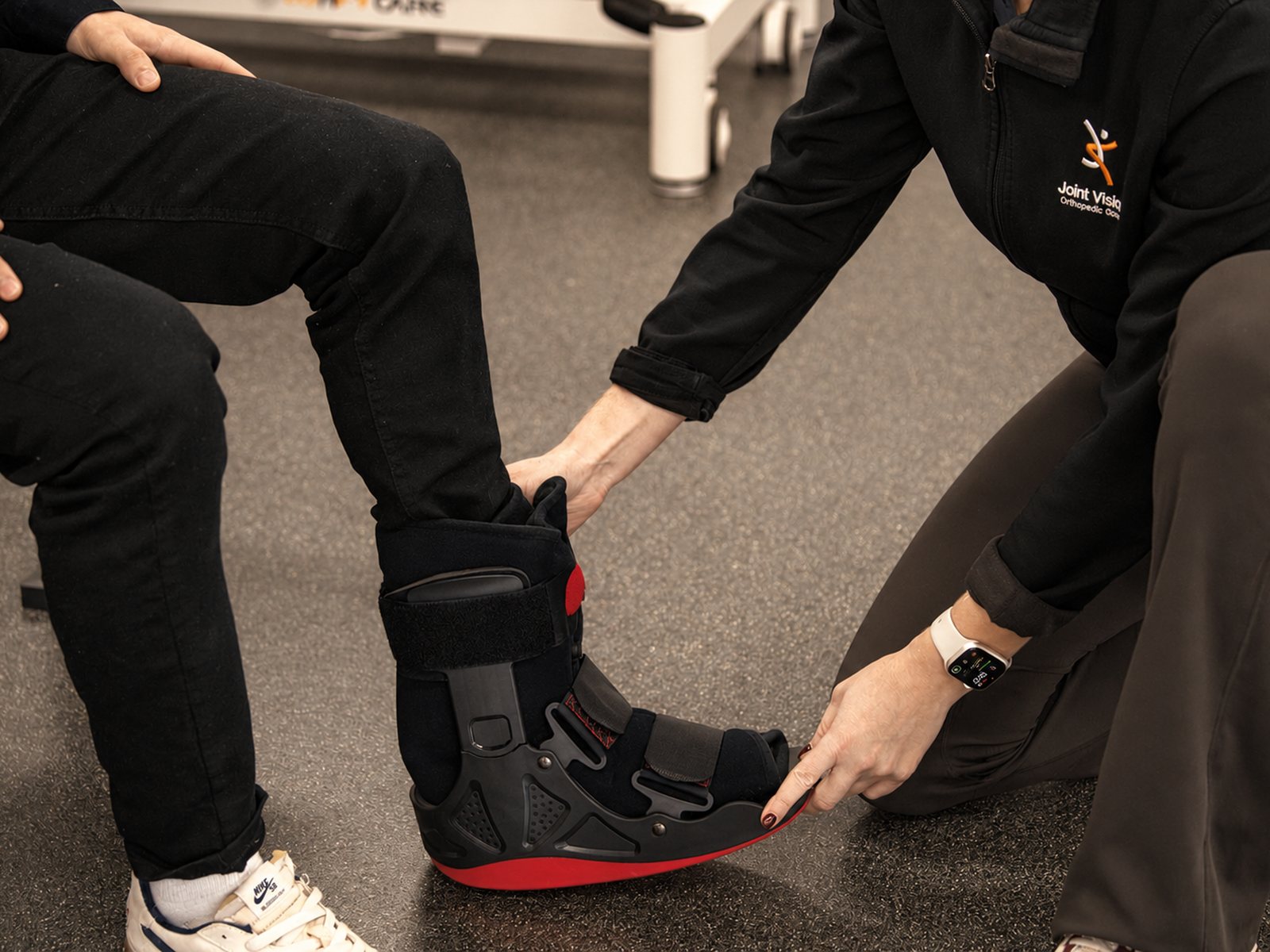 Clinician fitting a walking boot during a fracture and injury consultation at Joint Vision Orthopaedic Group