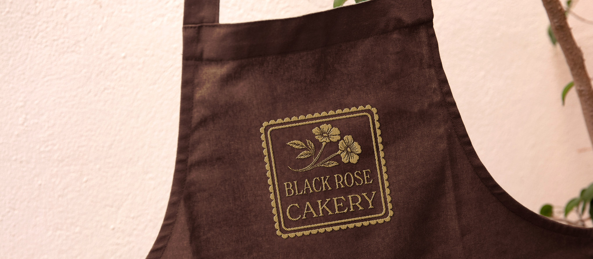 Black Rose Cakery branded apron with the embroidered rose logo, Winnipeg