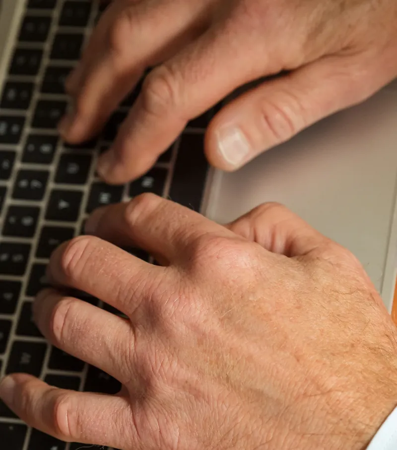 Dłonie adwokata na klawiaturze laptopa