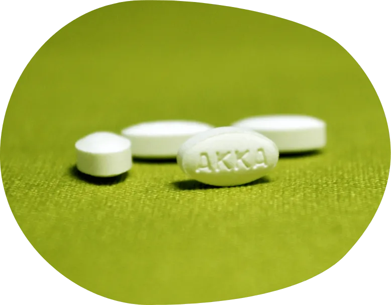 Image of four white tablets on lime green background
