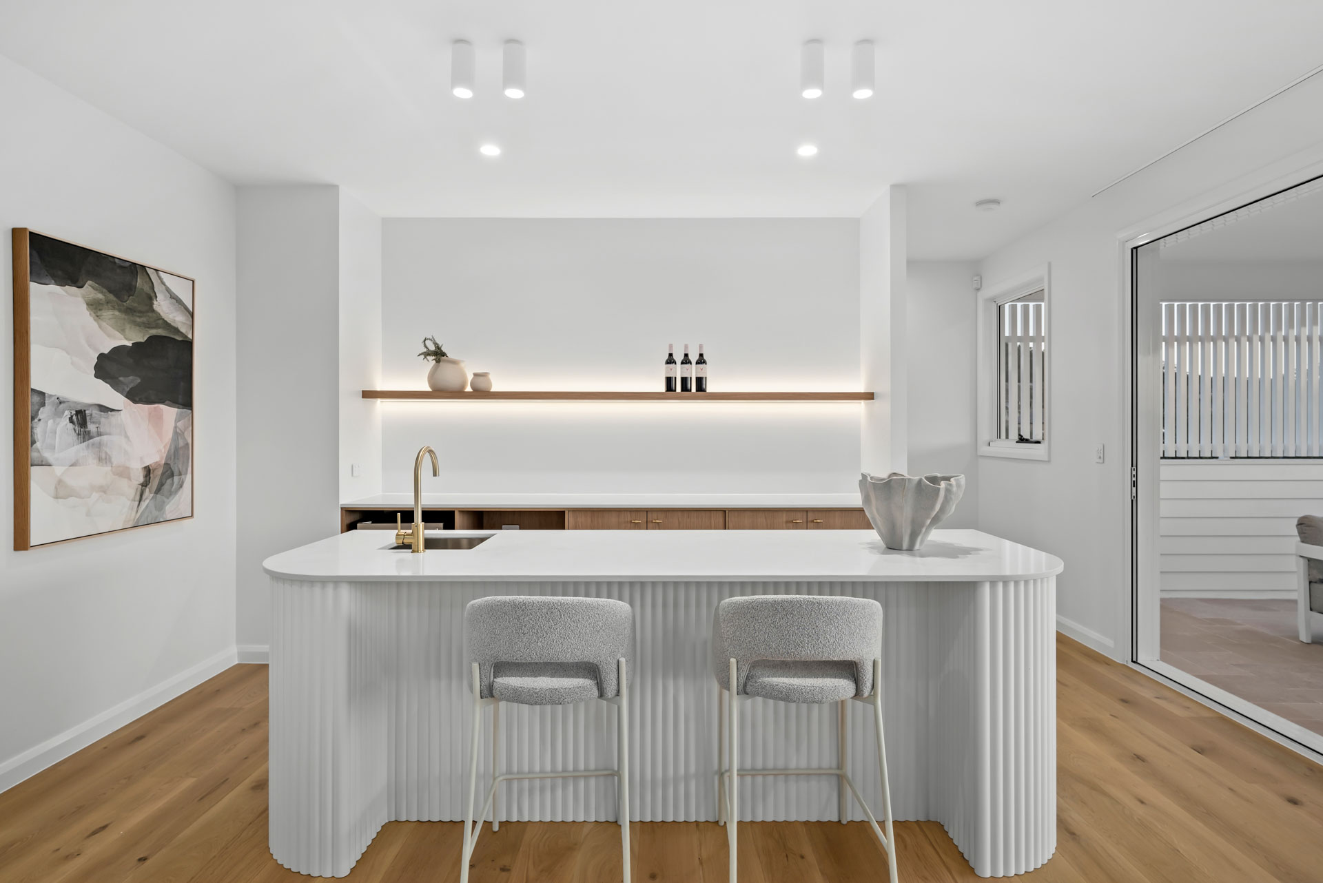Bar with fluted island and lit display shelf