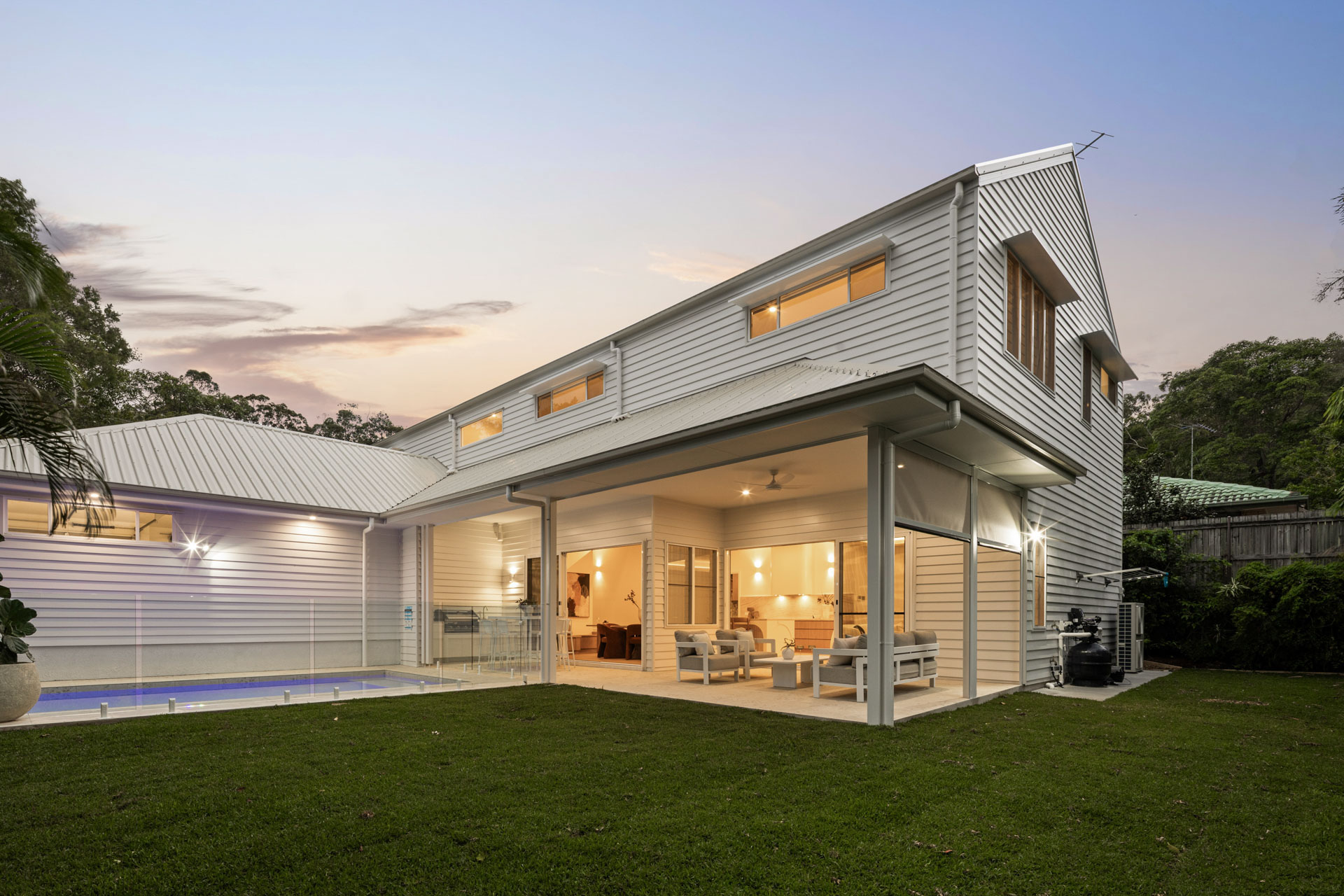 Rear elevation, lawn and pool at dusk