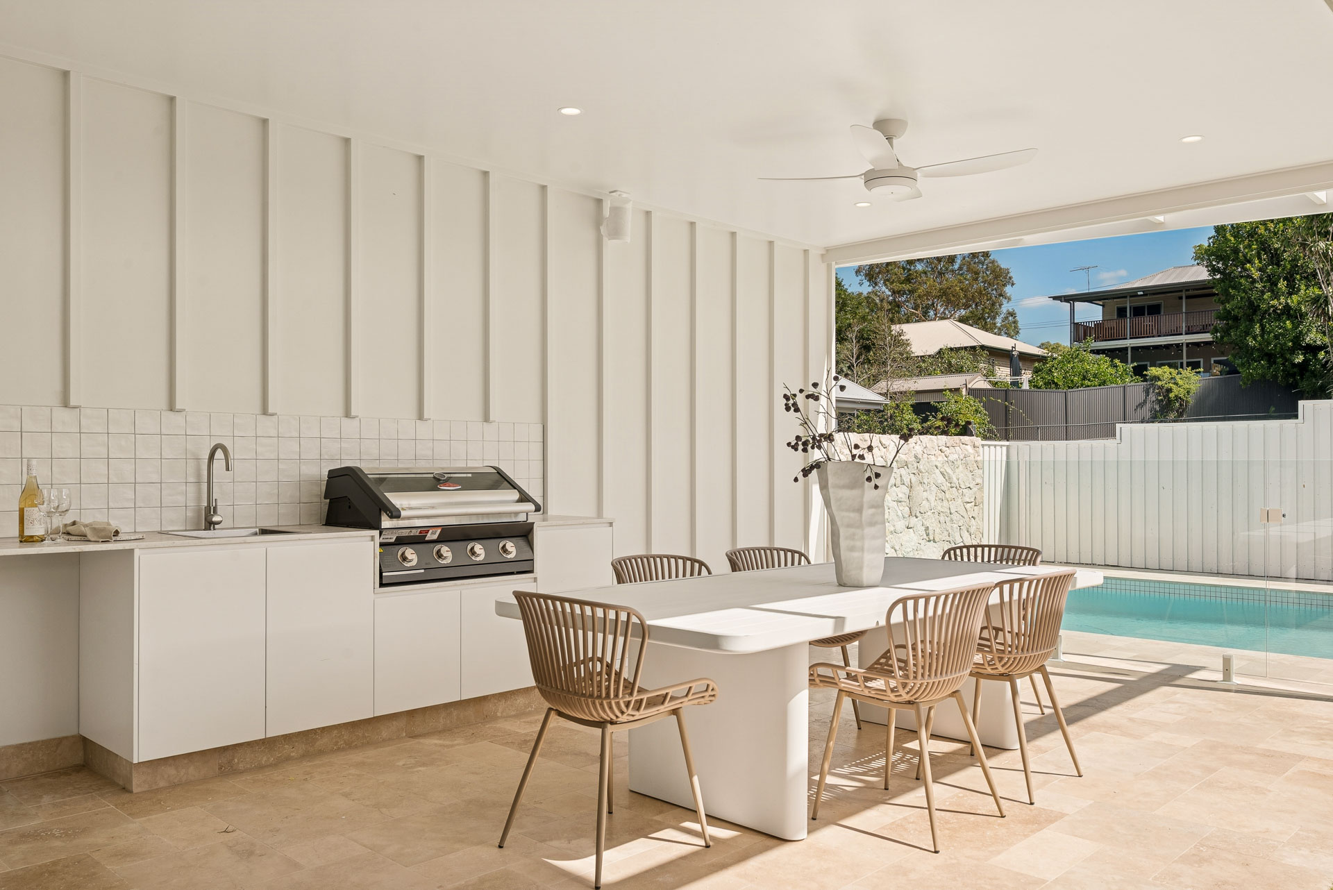 Covered outdoor kitchen and dining beside the pool