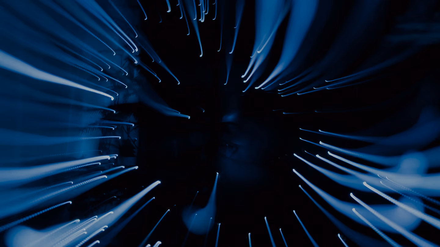 Abstract blue light trails radiating through a dark background, creating a dynamic digital technology effect.