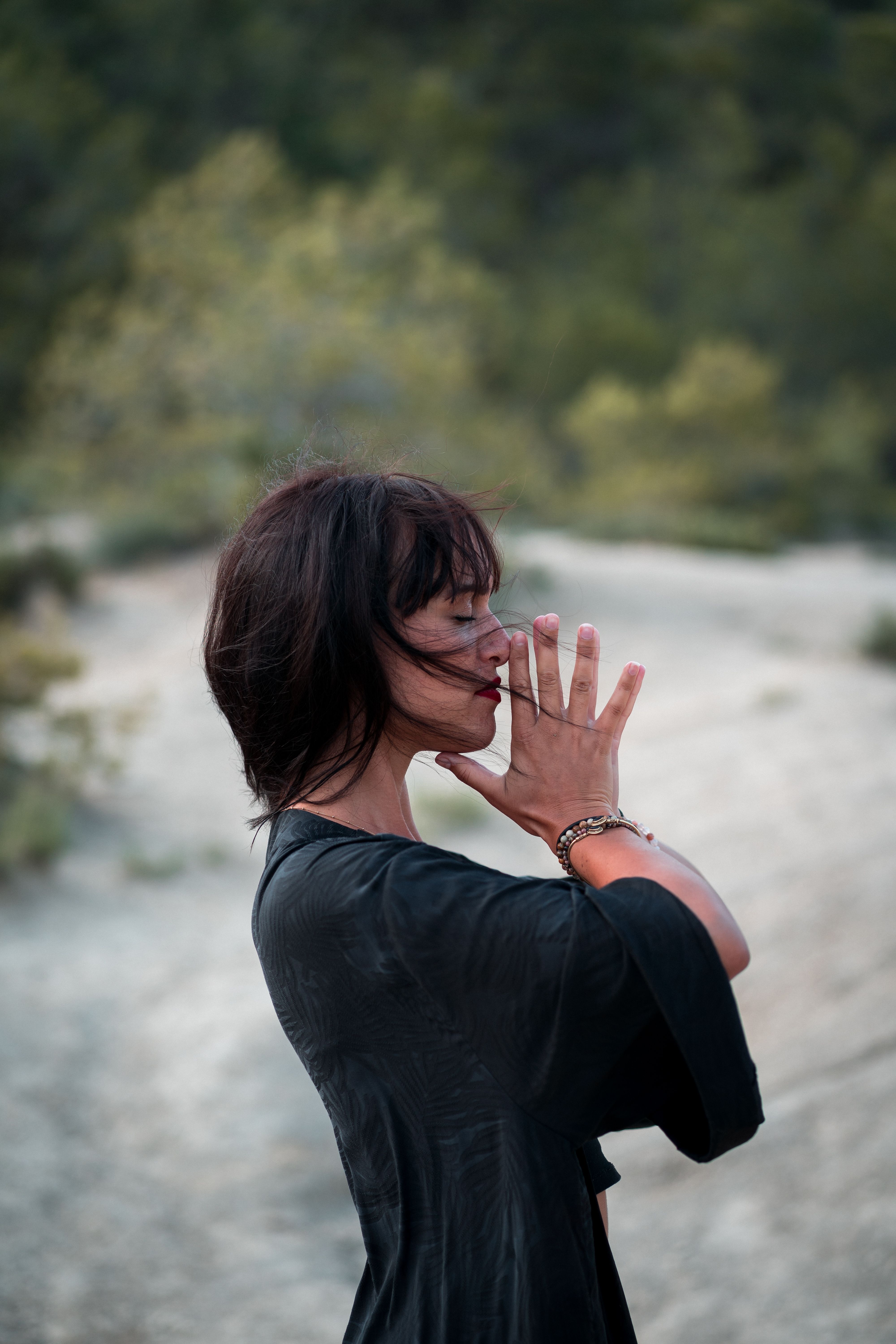 Woman meditating outdoors in a forest, grounding before the work ahead