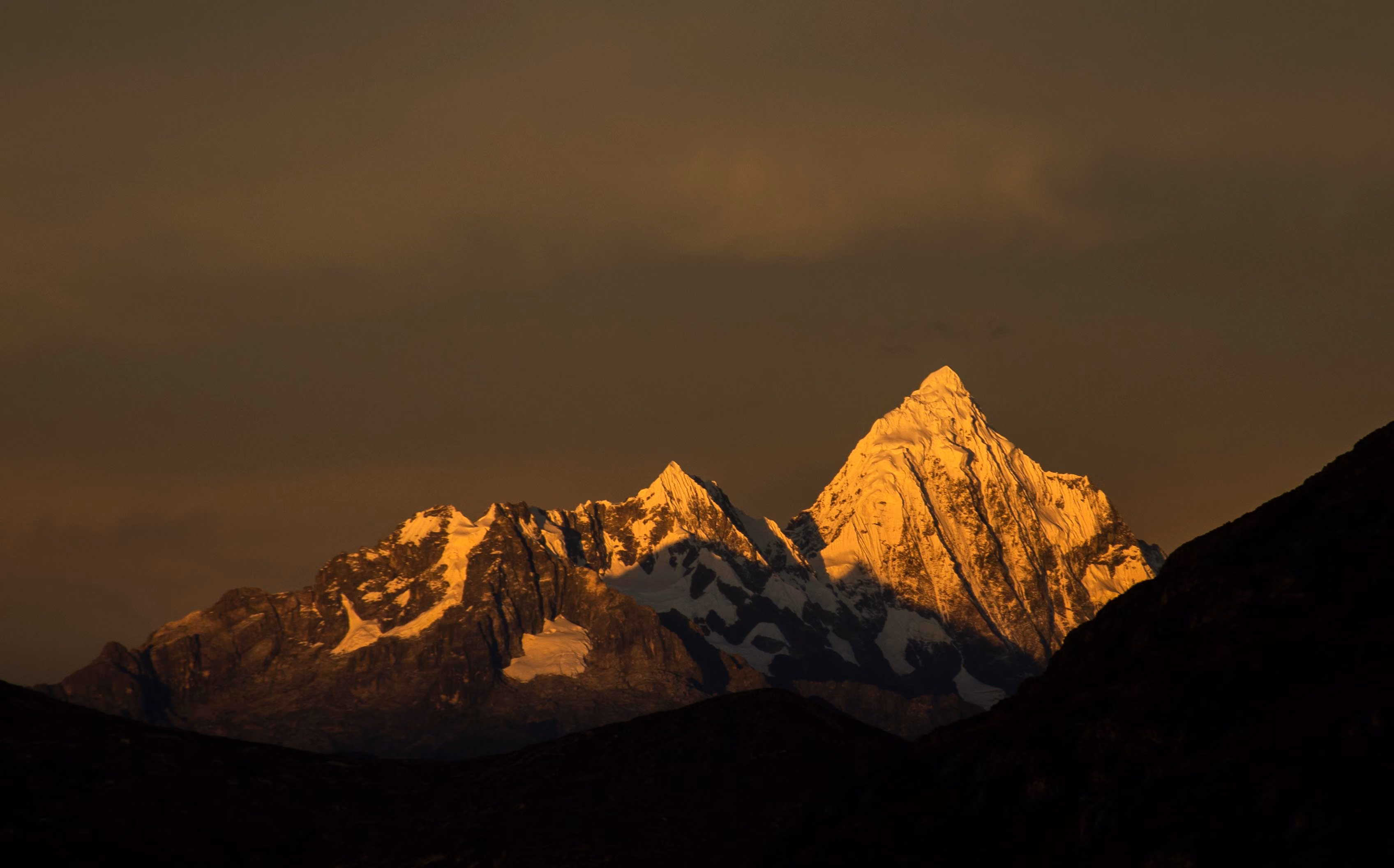 Golden sunrise over snow-covered mountain peaks