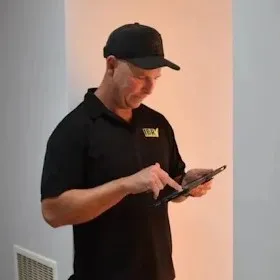 Andrew recording findings on a tablet during an inspection