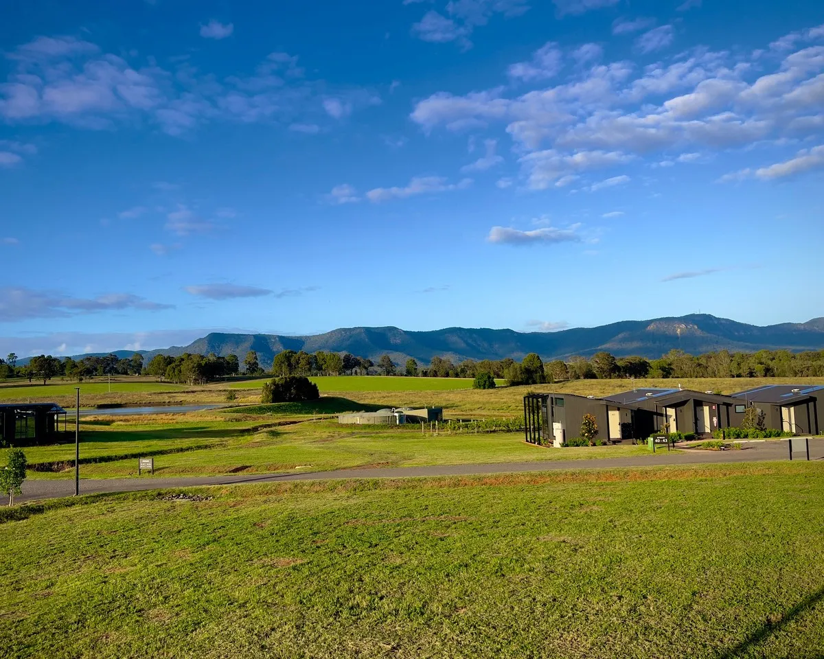 Farmland and homes below a mountain range in regional Victoria