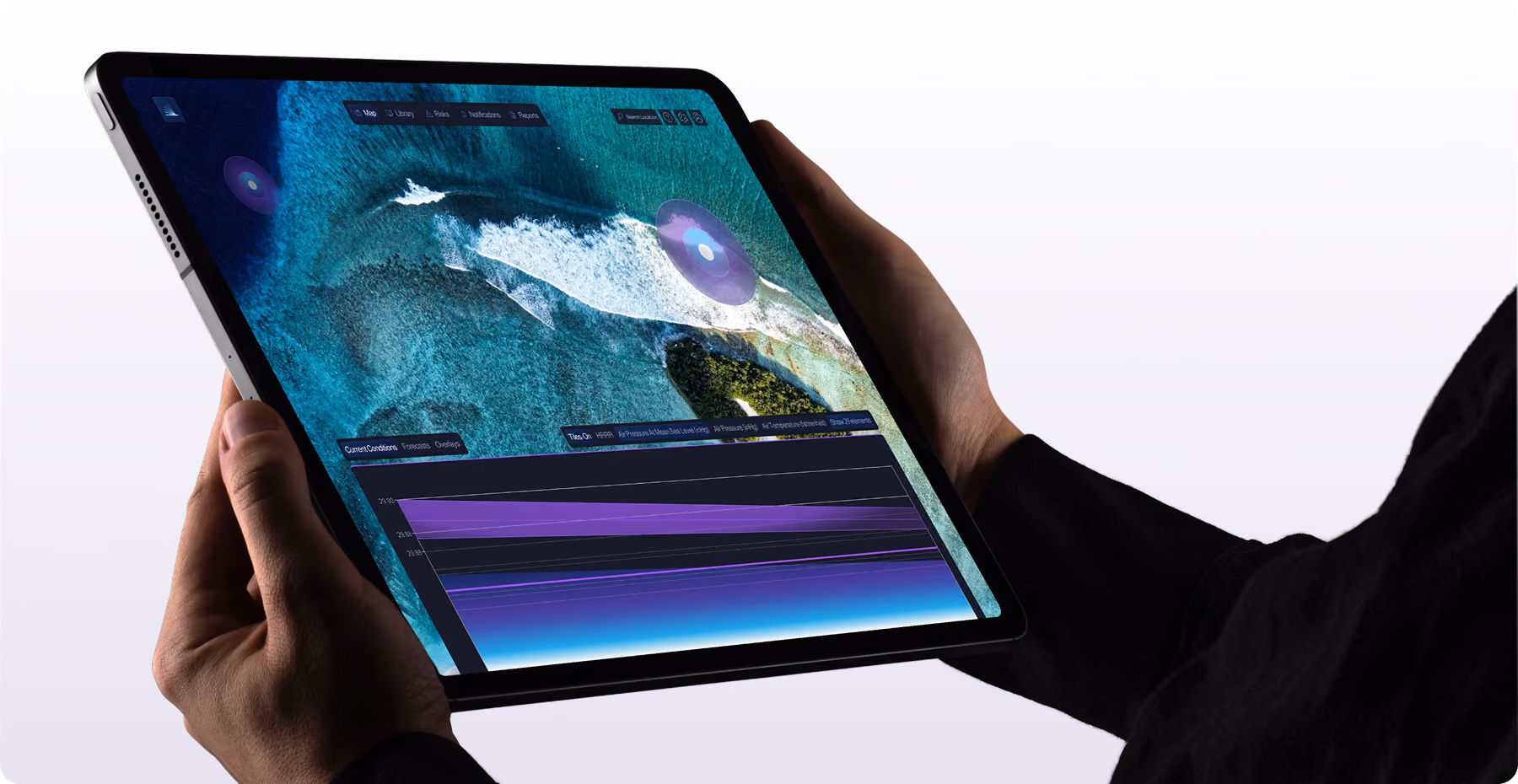 Hands holding a tablet displaying a digital map with oceanic features, wave patterns, and a purple data overlay, plus a chart with gradient purple and blue colors at the bottom.