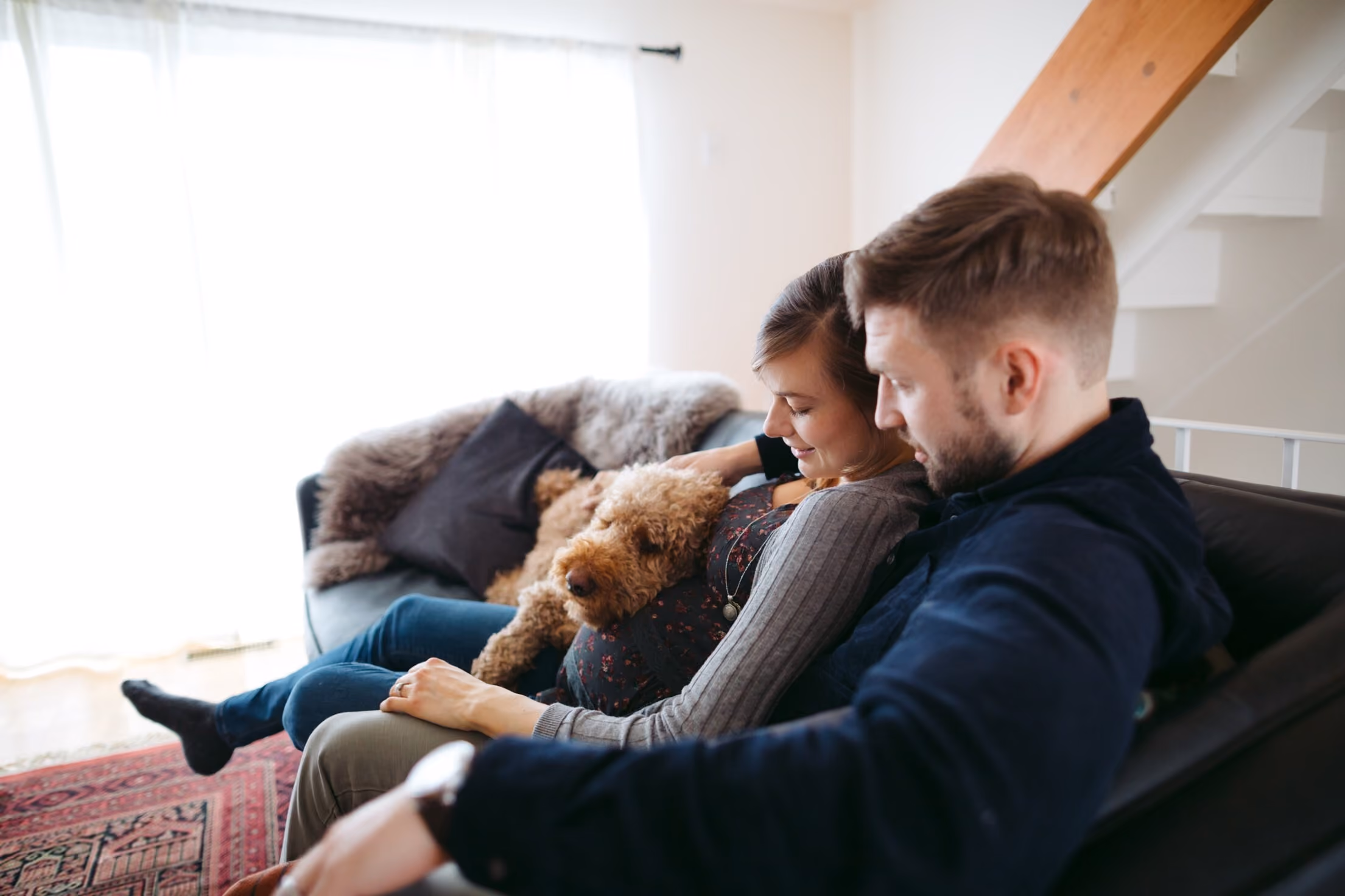 2 people and a dog sitting on a couch