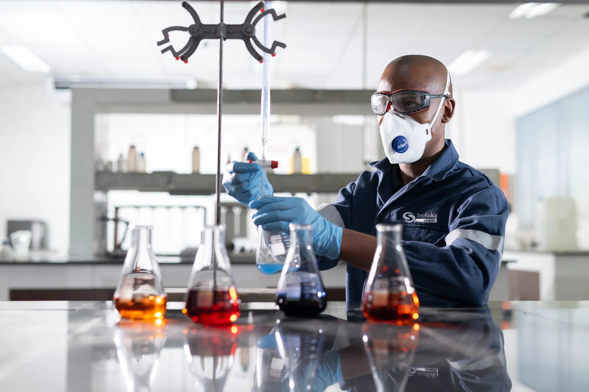 Laboratory technician testing samples in flasks at the Aganang plant laboratory