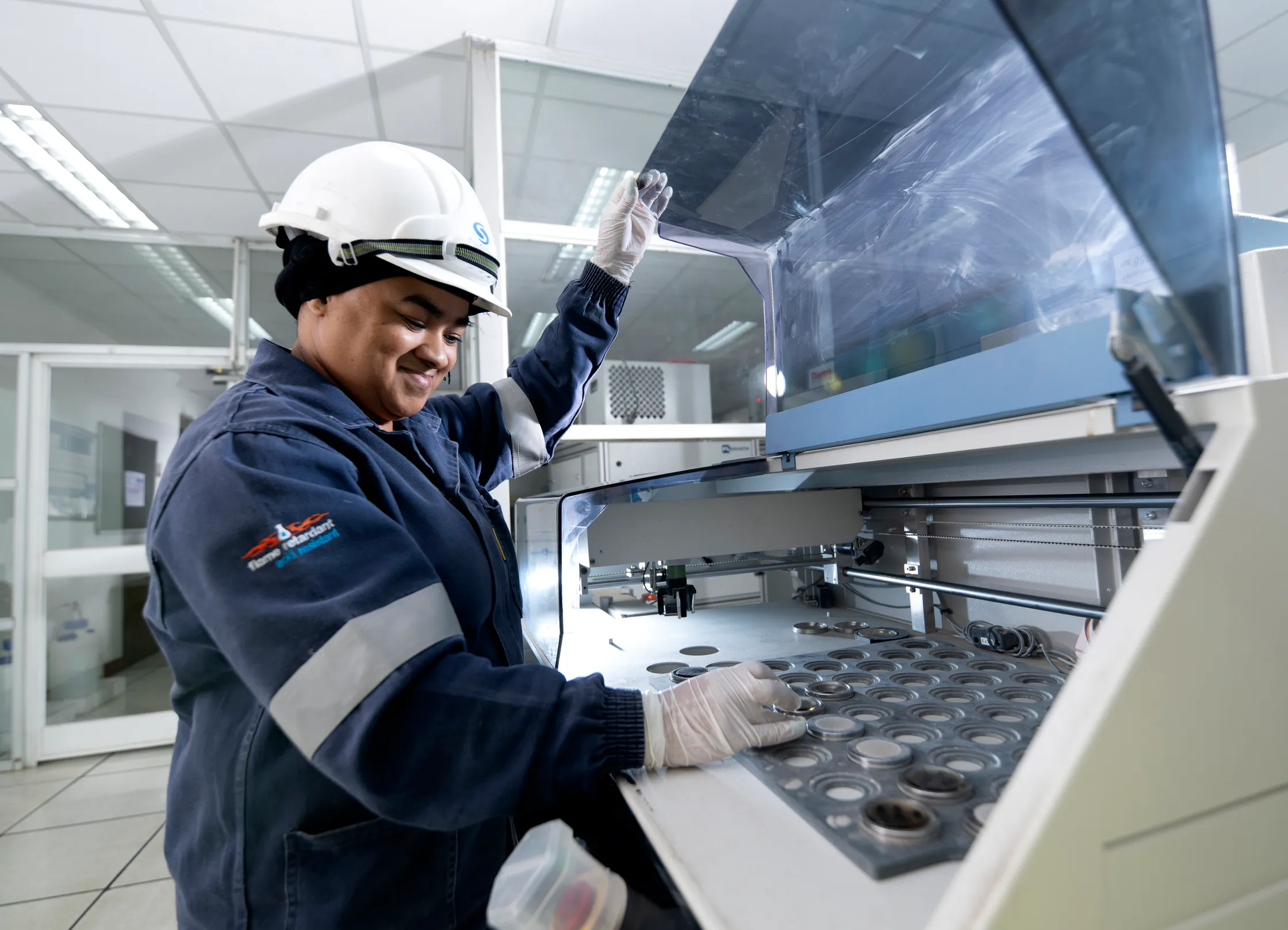 Laboratory technician loading samples into testing equipment at the Aganang plant