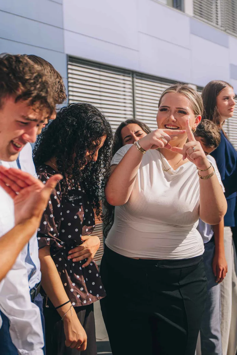 Azubis lachen gemeinsam vor dem Bankgebäude