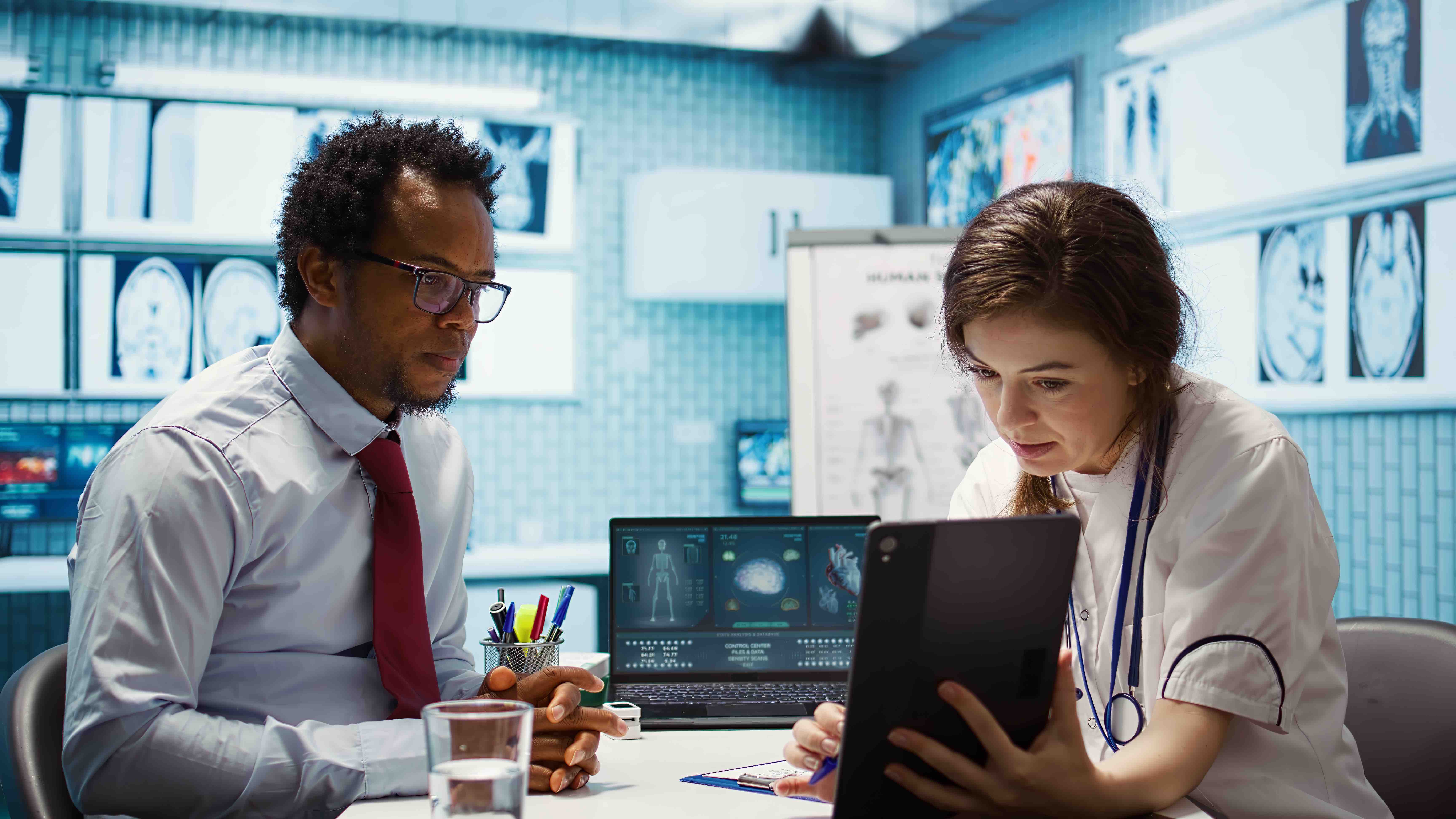 General practitioner sharing test findings with a patient on a tablet