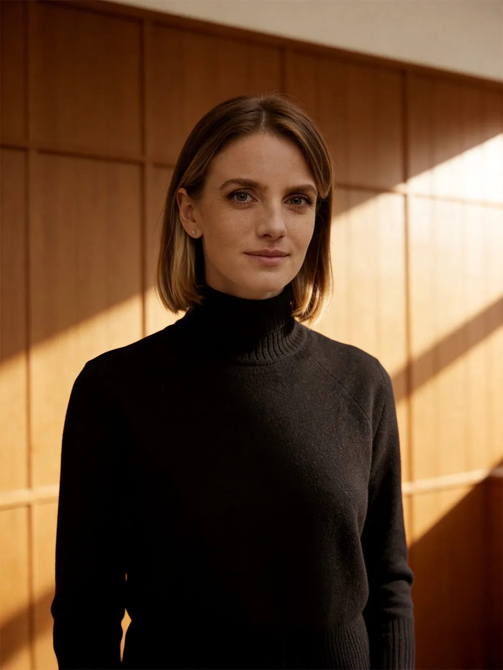 A woman standing in front of a wooden wall.