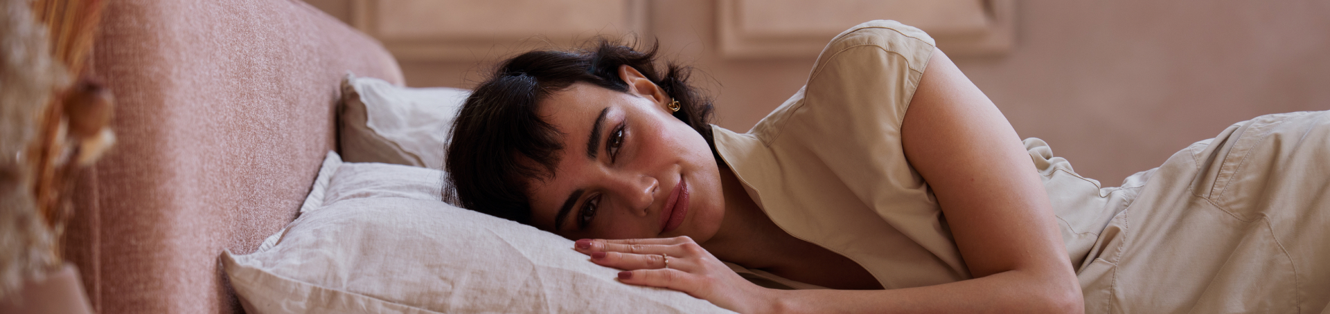 Vrouw liggend in bed met wit beddengoed