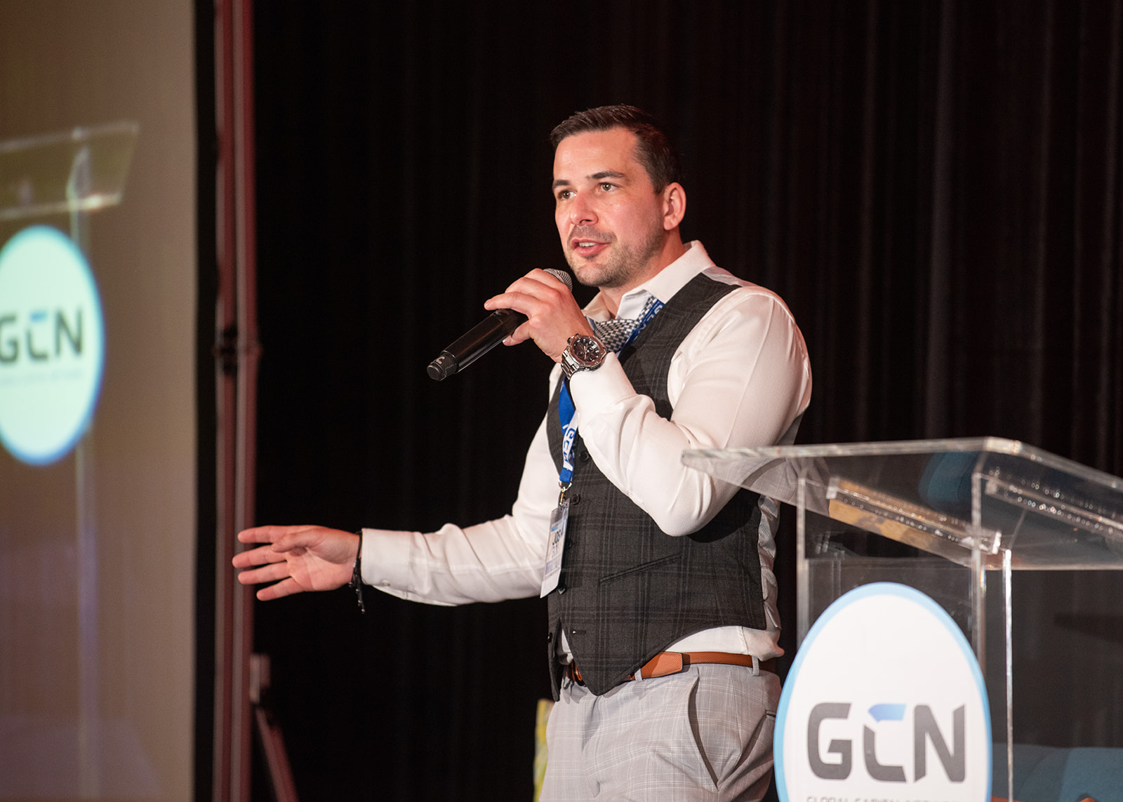 Josh Bois speaking on stage with a microphone