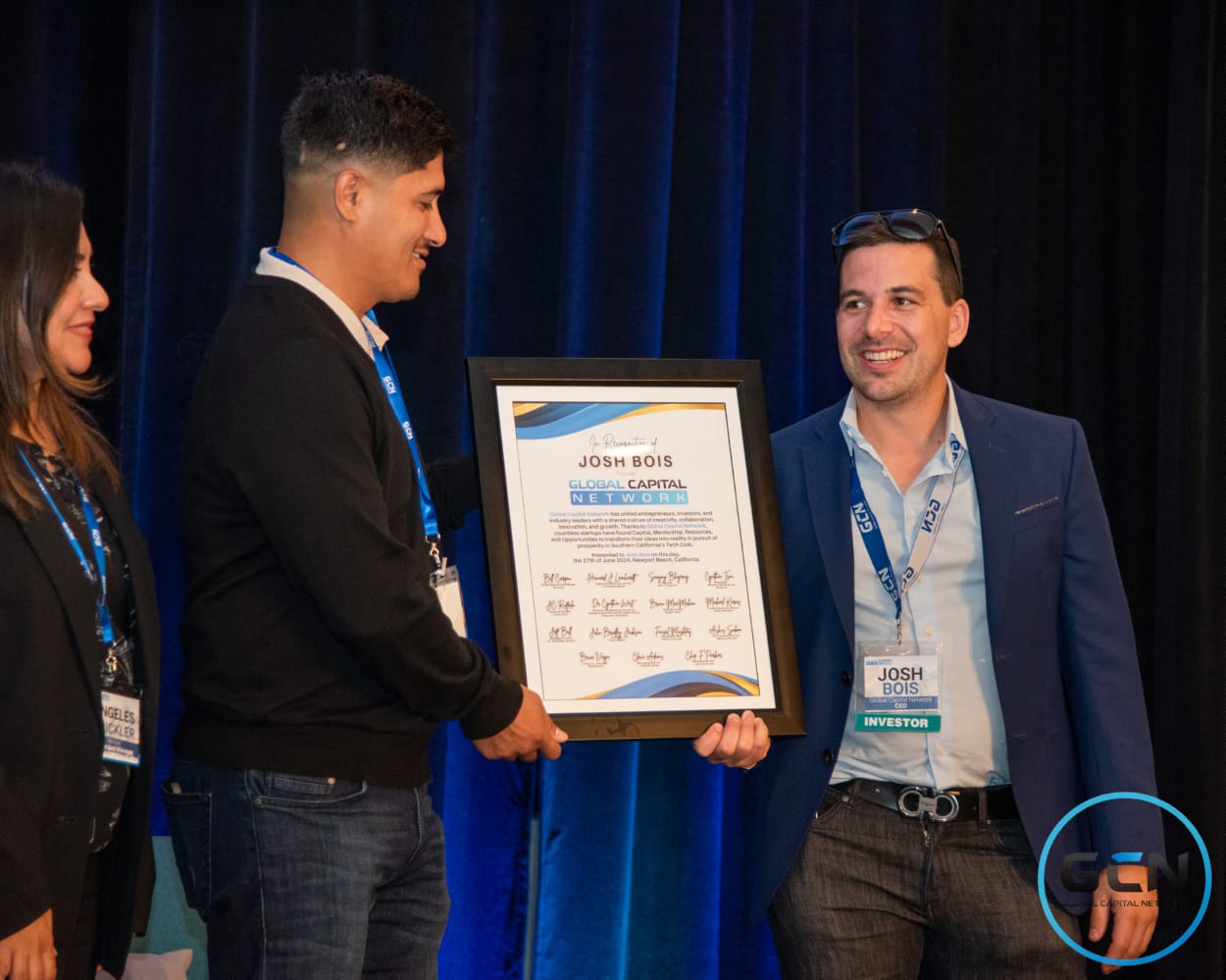 Josh Bois receiving a framed recognition award signed by investors