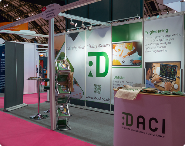 DACI exhibition stand with branded panels and display screens at a trade show.