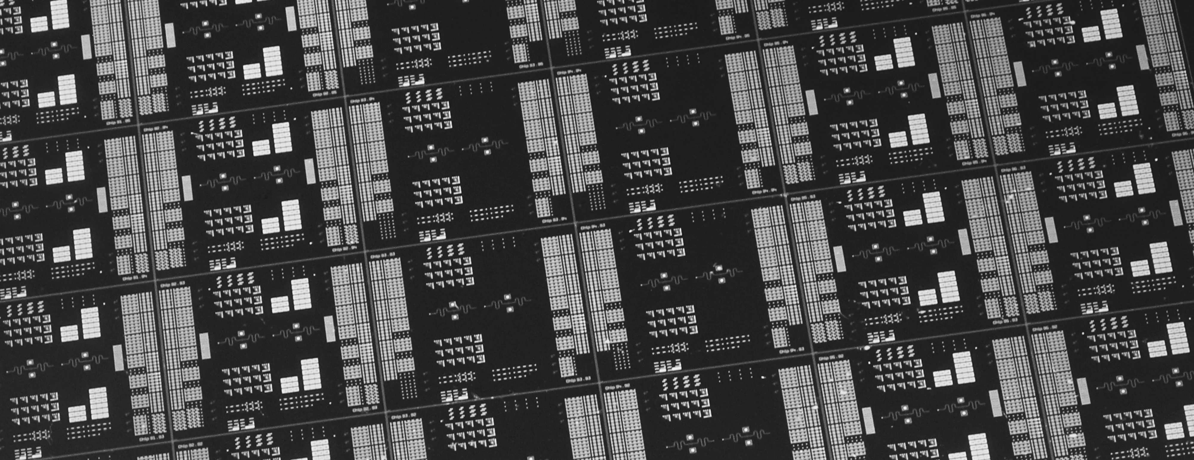 Silicon wafer patterned with rows of superconducting transistor chips