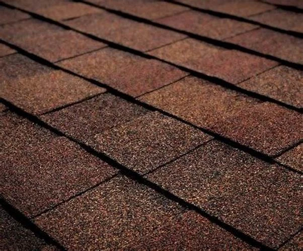 Close-up of the layered texture and varied brown tones of roofing shingles