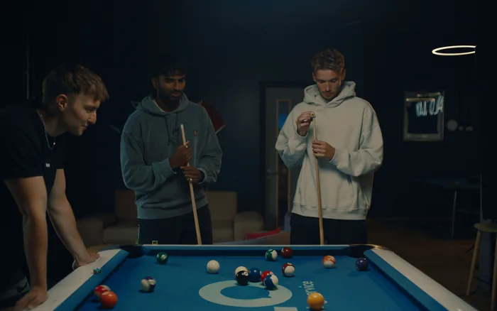 Three Halo colleagues playing pool in the office break area