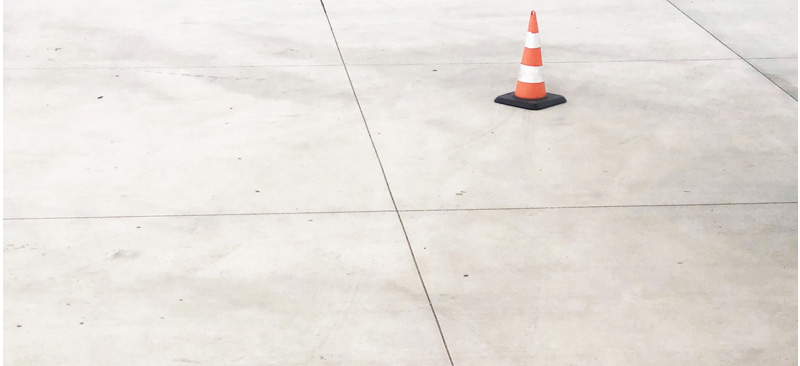 A traffic cone on a light concrete surface