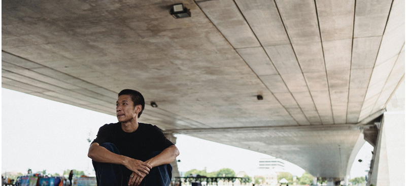 Man sitting under suspended concrete slabs