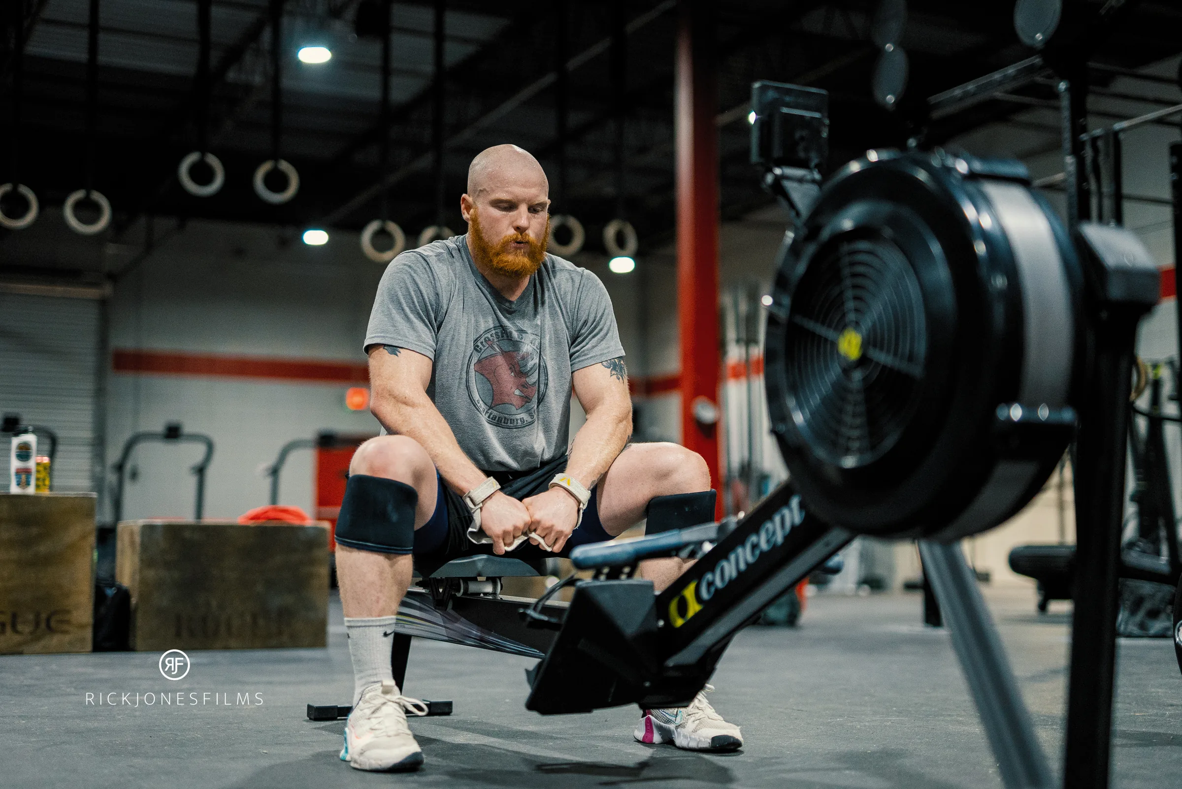 Taylor sitting on a rowing machine catching his breath between sets.