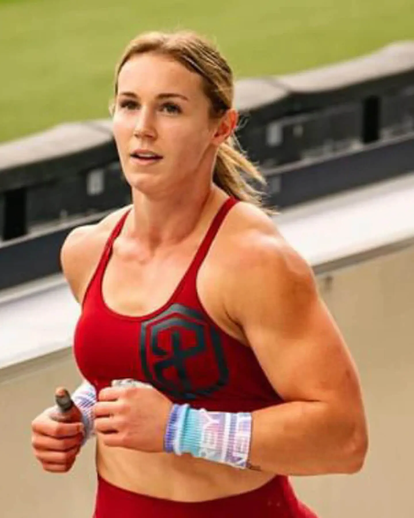 Sentinel athlete Morgan Porter running in a red training top at a stadium.