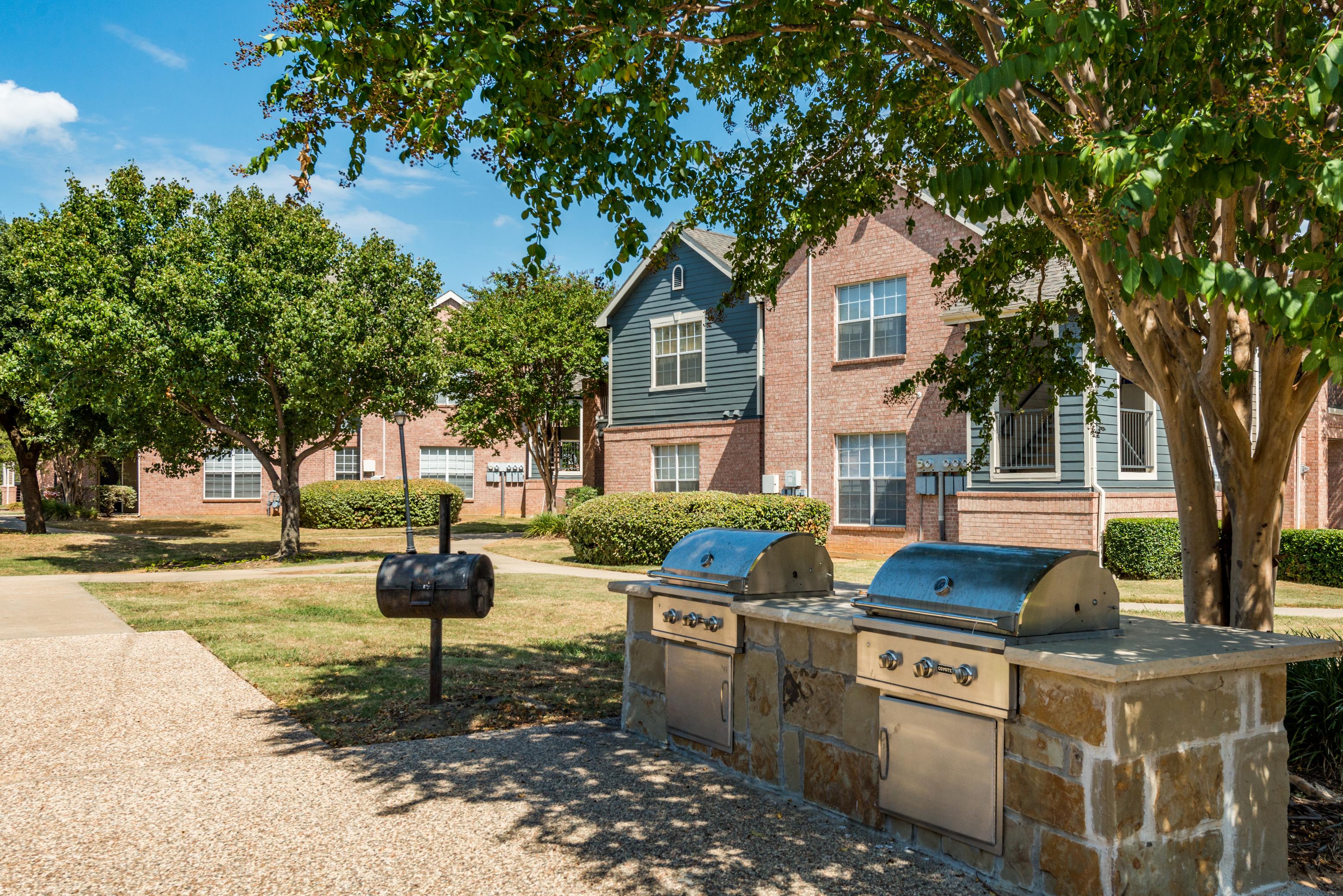 Outdoor grilling area with dual propane grills and charcoal grill