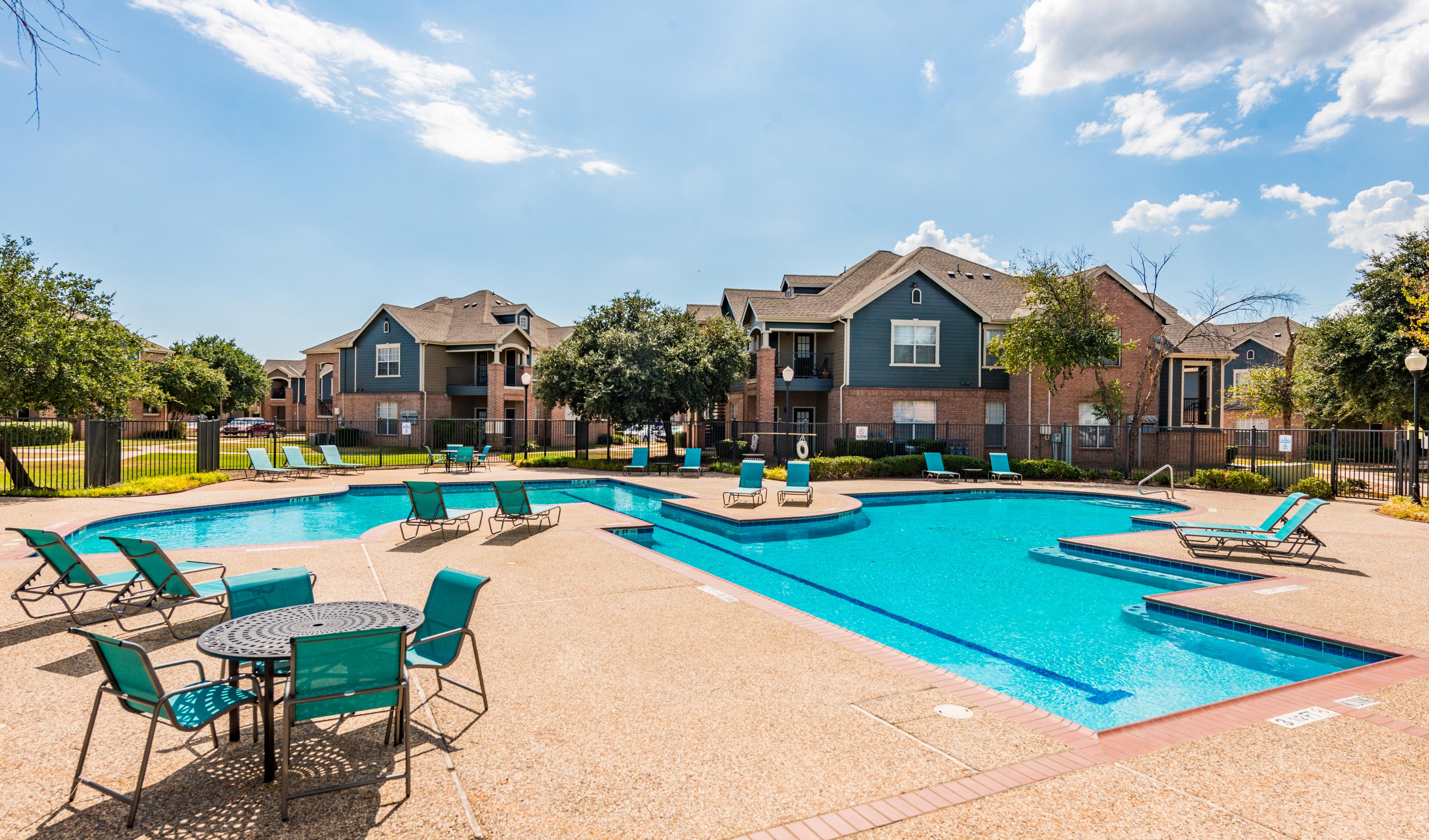 Wide view of swimming pool with apartment buildings in the background