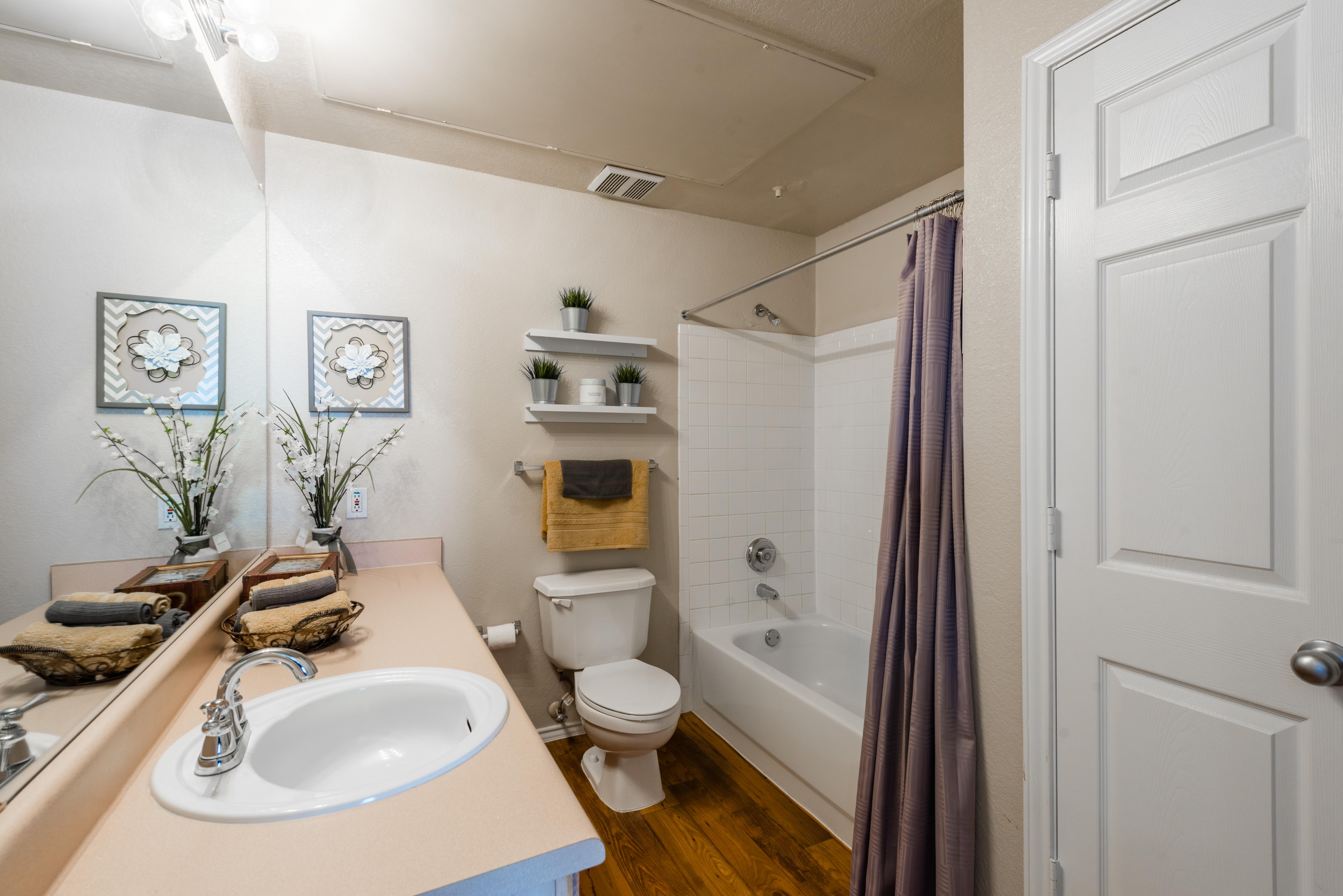 Bathroom with bathtub and built-in shelving above toilet