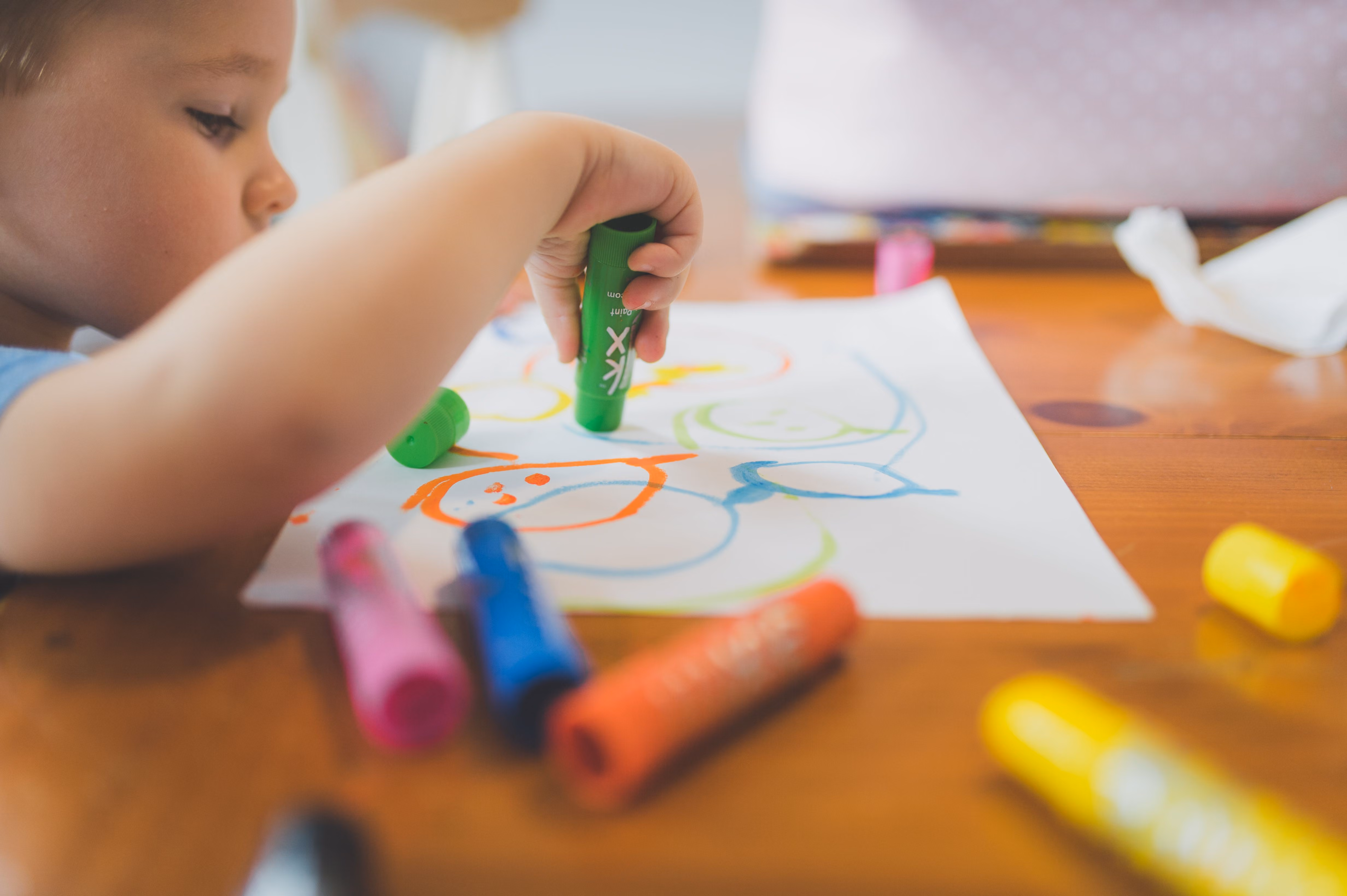 Kid's Church photo. A child colors a picture with markers while sitting at a table.