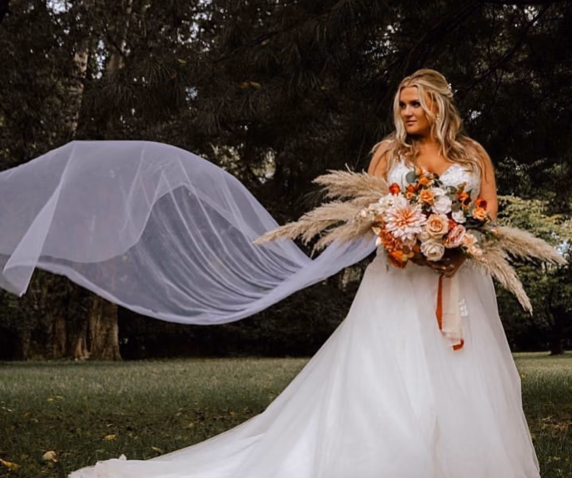 Bride with a flowing veil holding an autumn pampas bouquet