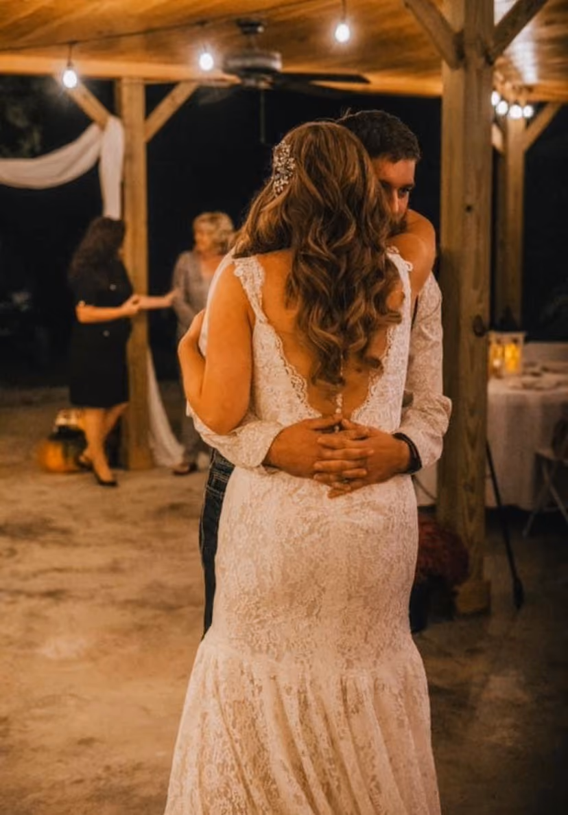 Bride and groom during their first dance at an evening barn reception