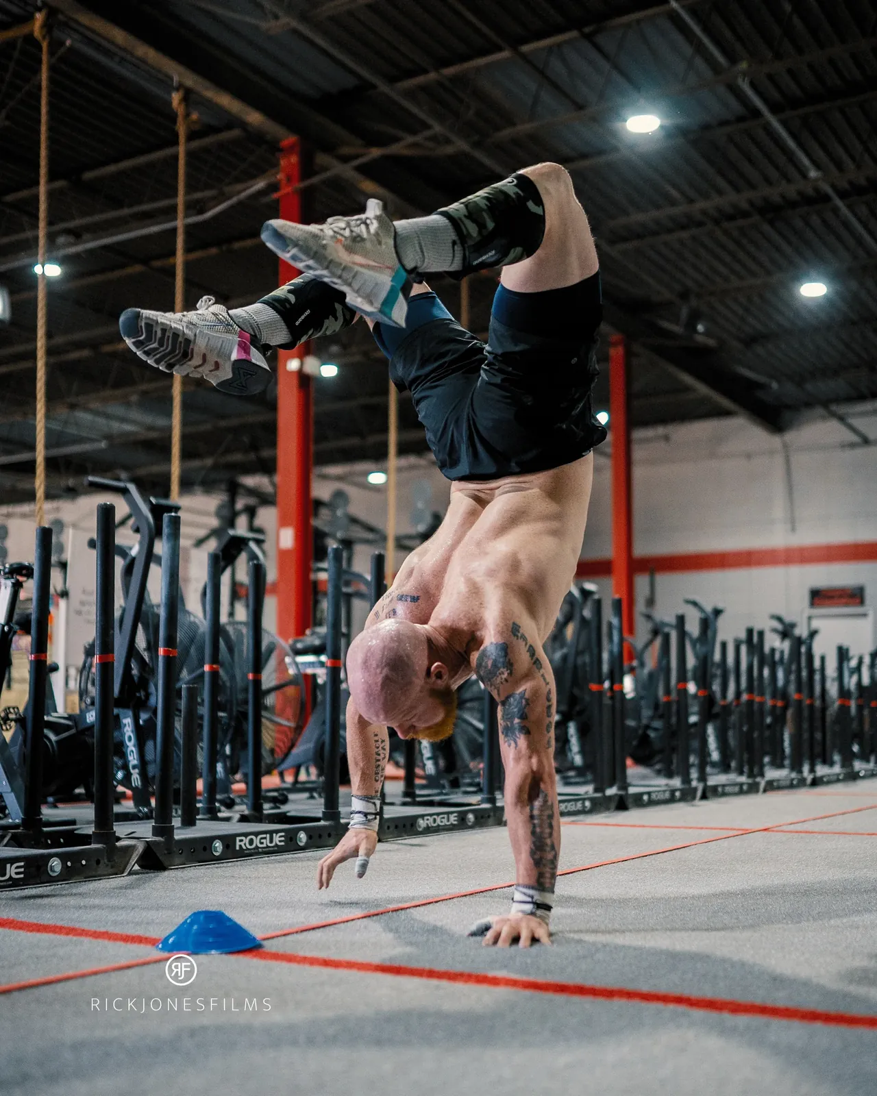 Taylor upside down mid handstand walk along a line on the gym floor.