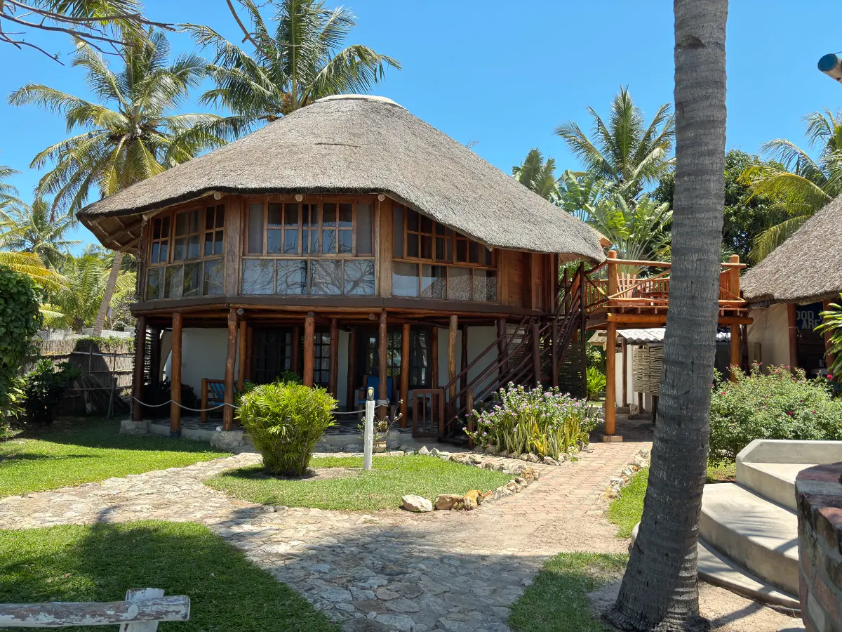 Traditional thatched-roof accommodation surrounded by tropical greenery at SAMARA Lodge in Vilanculos.