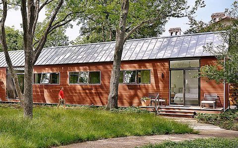 Wood-and-red cabin exterior surrounded by trees.