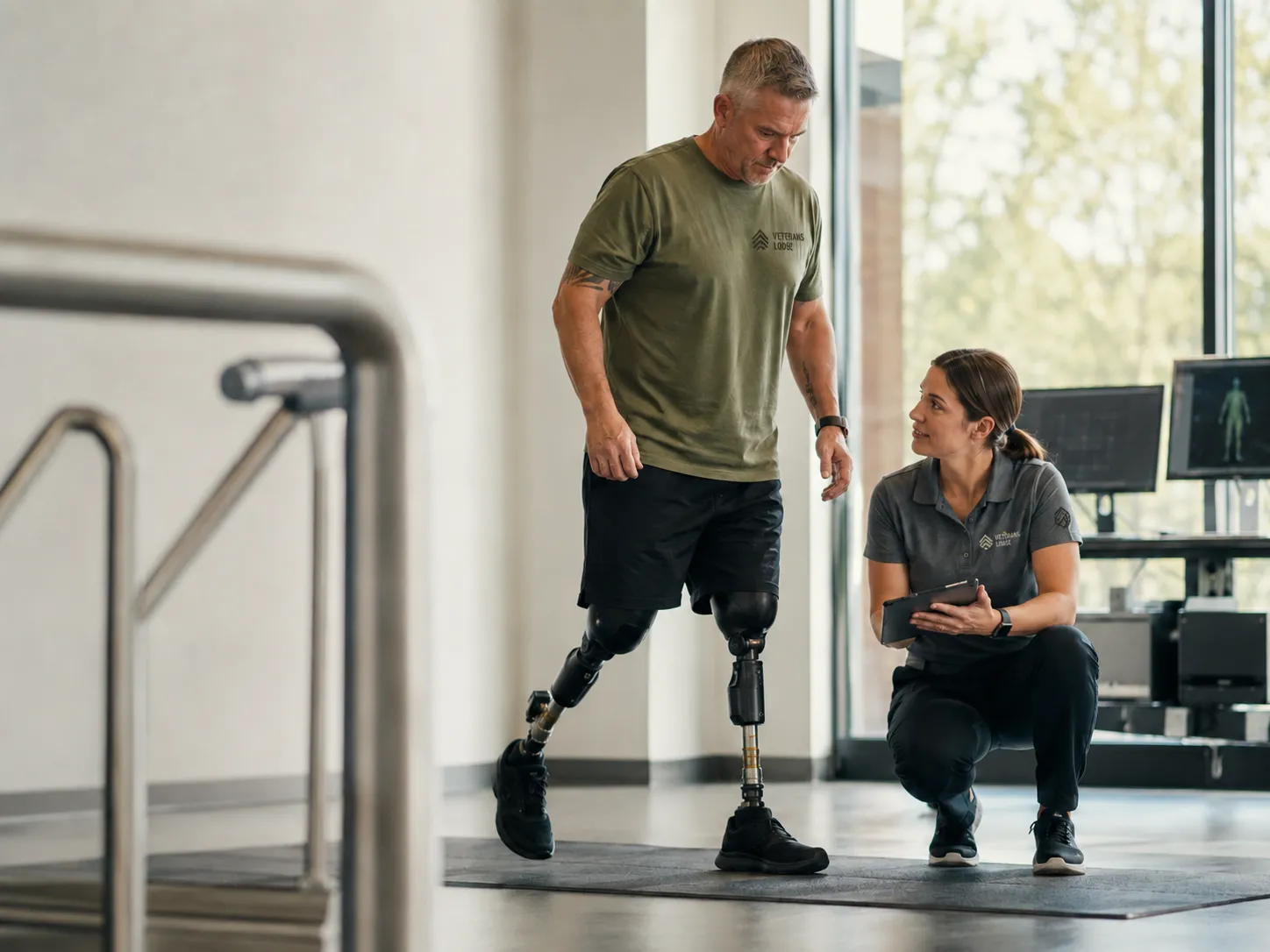 A veteran doing gait therapy with a prosthetic leg beside advanced monitoring equipment.