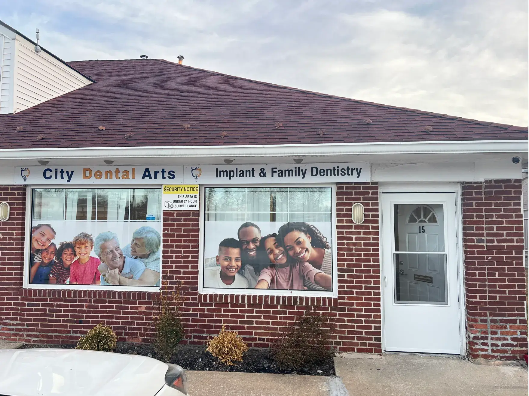 Brick dental office with large family photos on windows and sign reading "City Dental Arts."