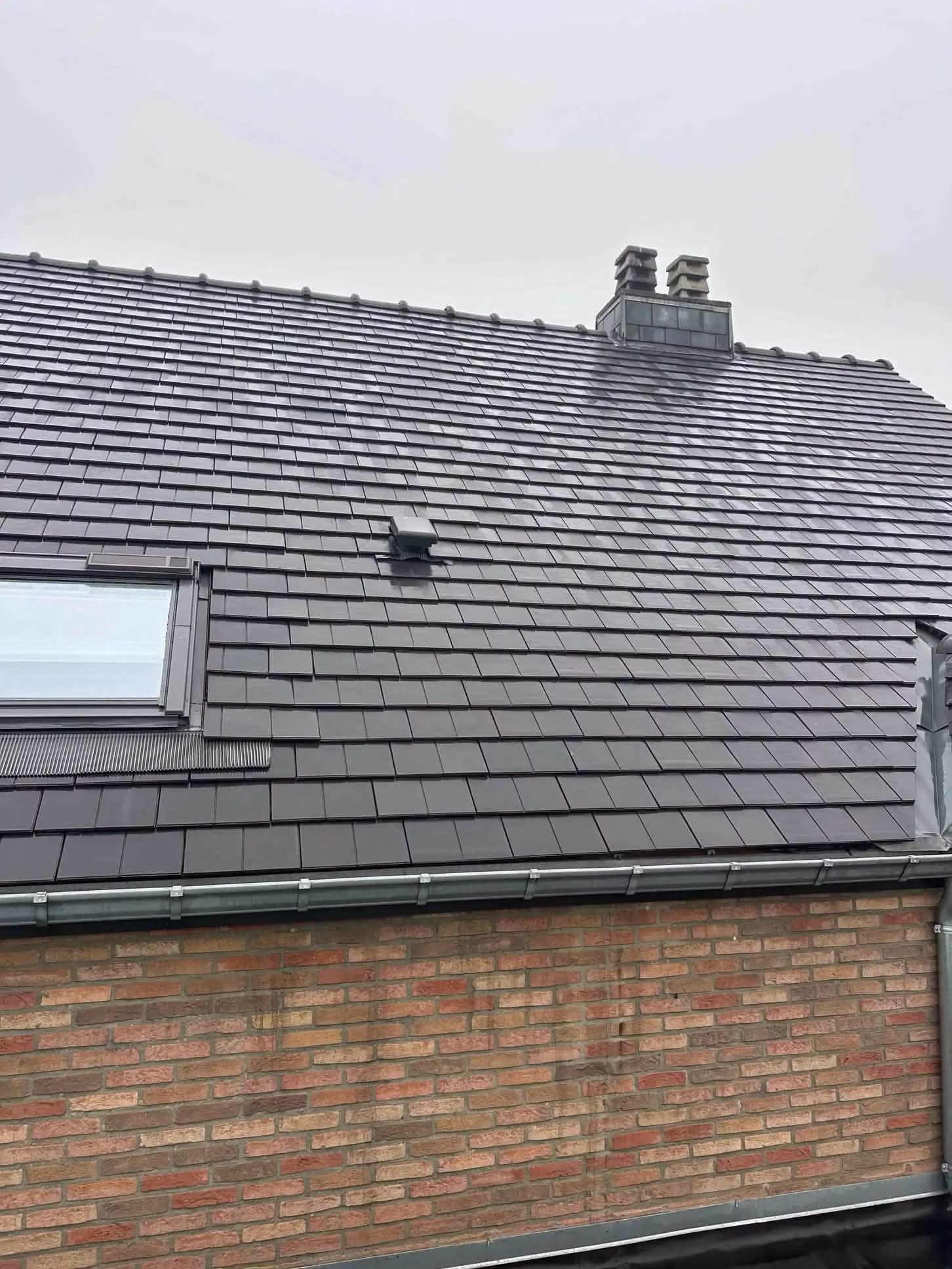 Toiture propre avec fenêtre de toit après démoussage