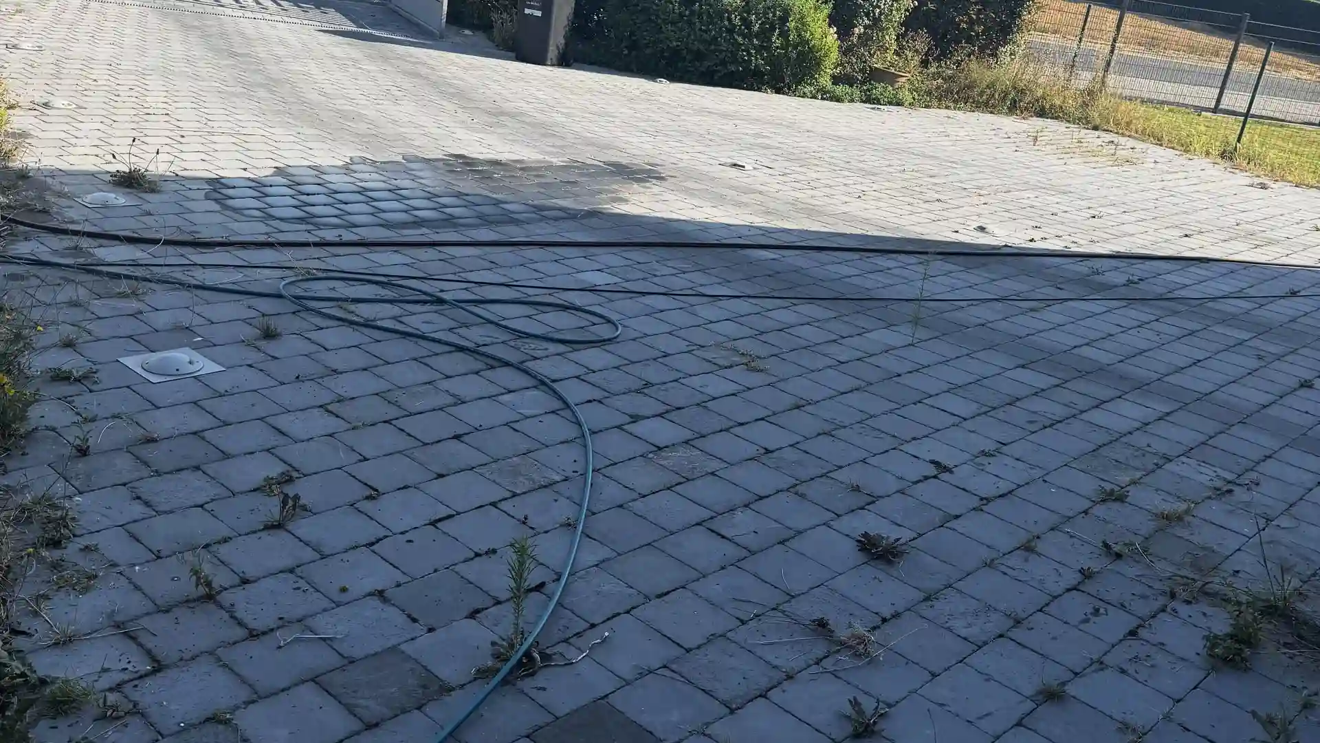 Terrasse en pavés anthracite avec spots encastrés, avant nettoyage
