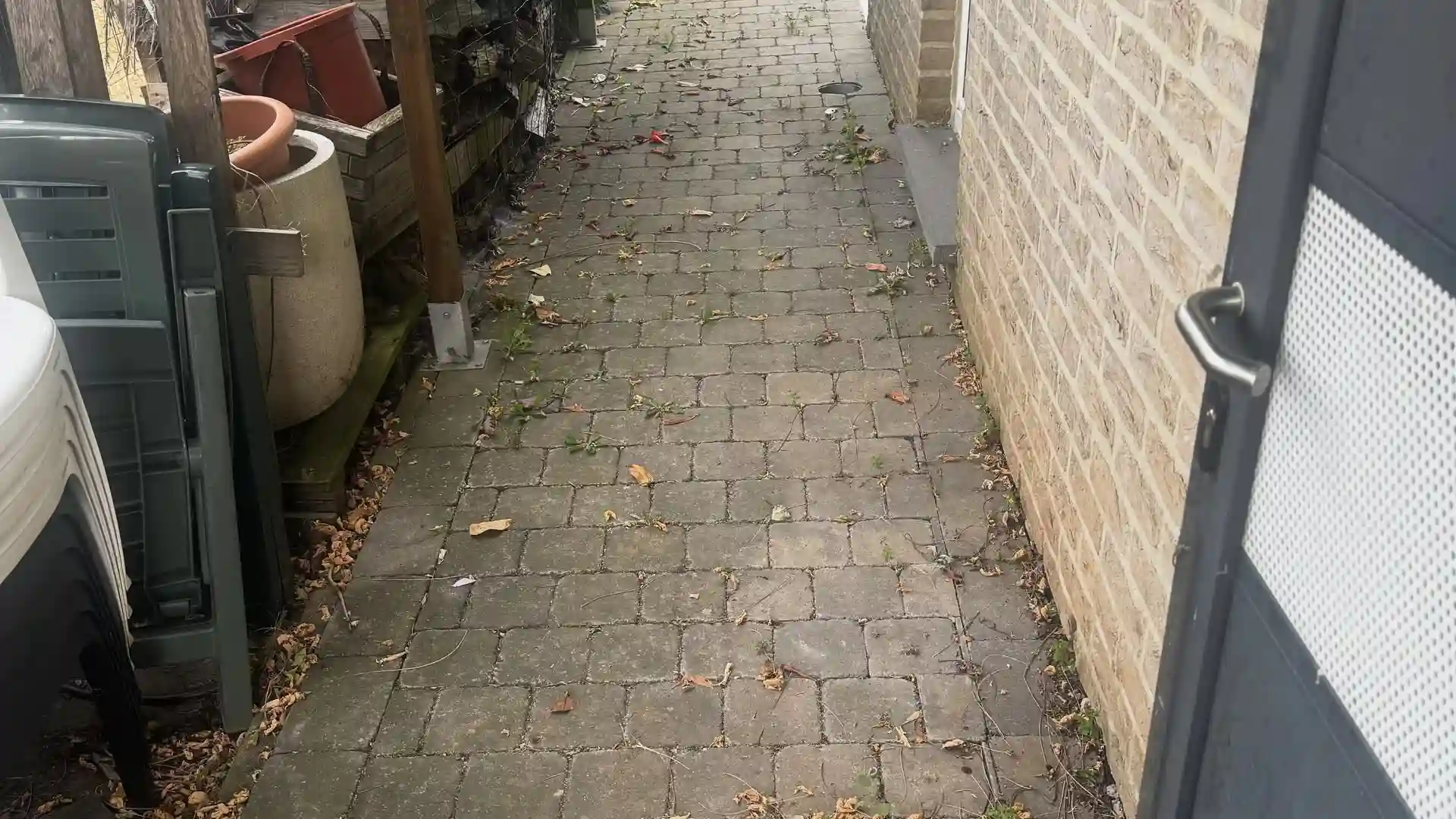Passage en pavés le long d'une maison, avant nettoyage