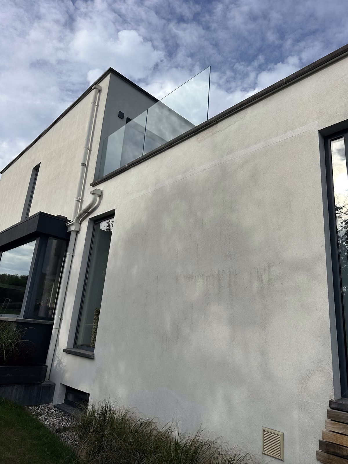 Façade en crépi blanc avec traces noires, avant nettoyage
