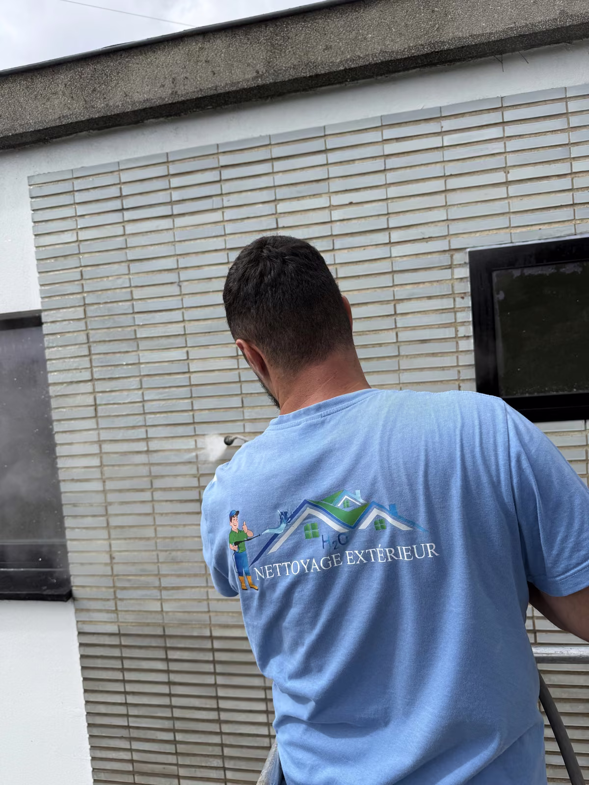 Nettoyage d'un parement de façade par un technicien Nettoyage Extérieur