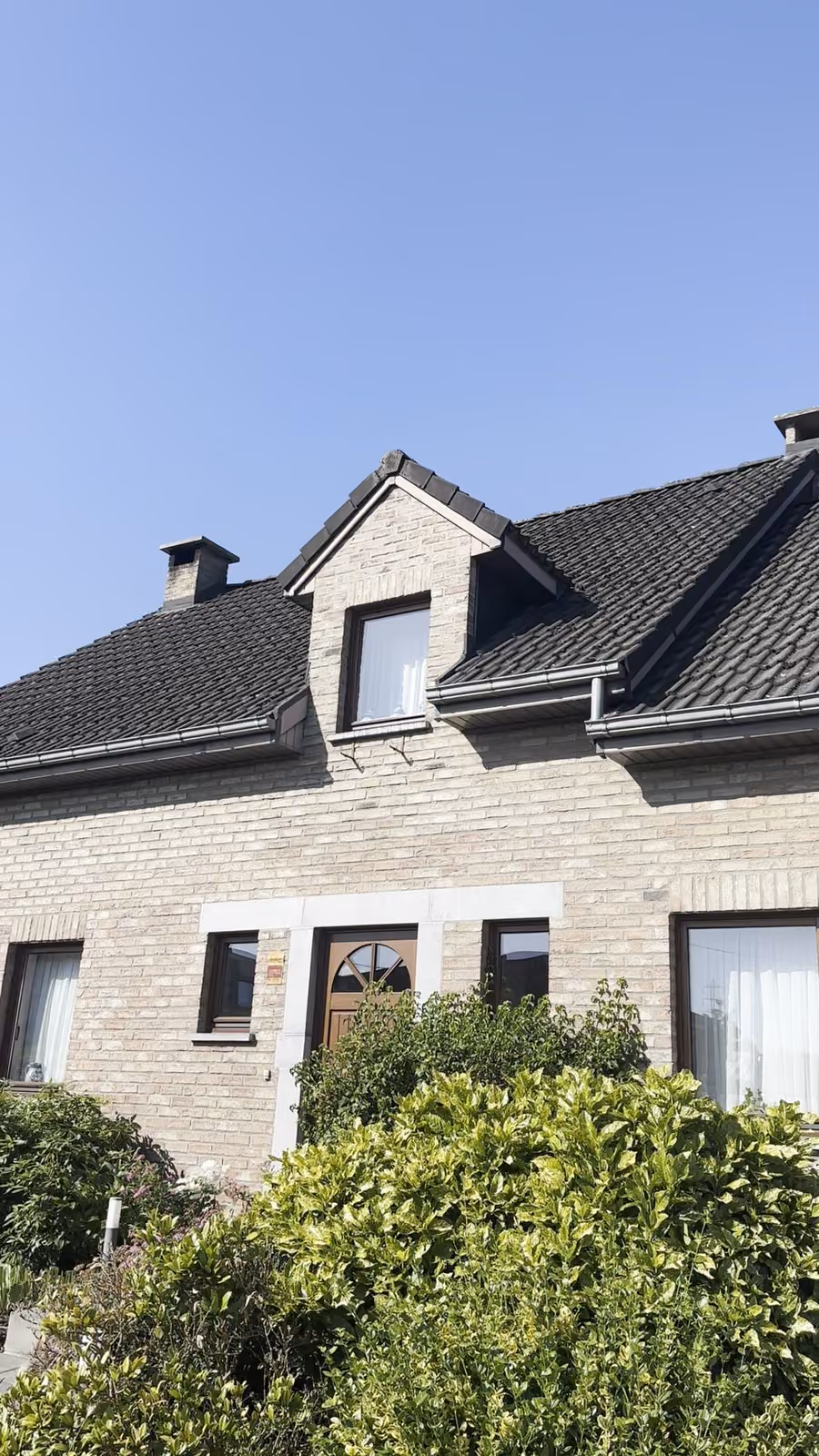 Maison aux gouttières et toiture propres après intervention